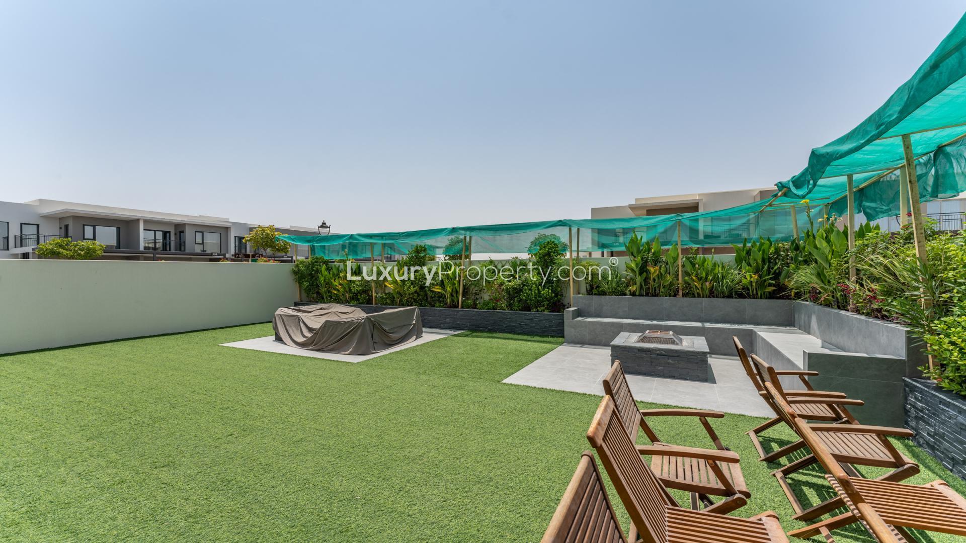 Vacant townhouse interior with large windows, overlooking landscaped garden in Arabian Ranches 2