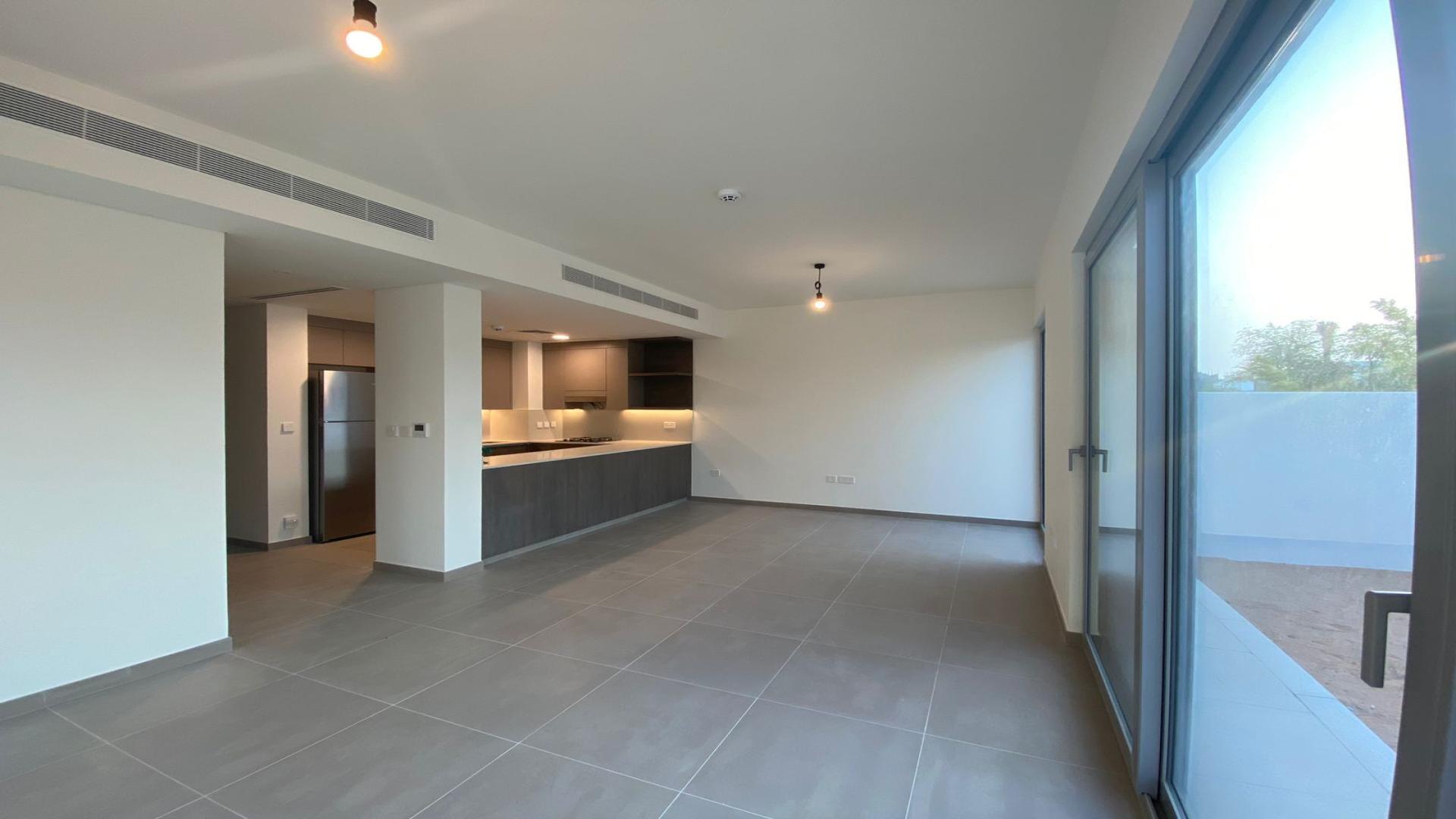 Empty bedroom with large window, tiled floor, and balcony view in Elan, Tilal Al Ghaf townhouse