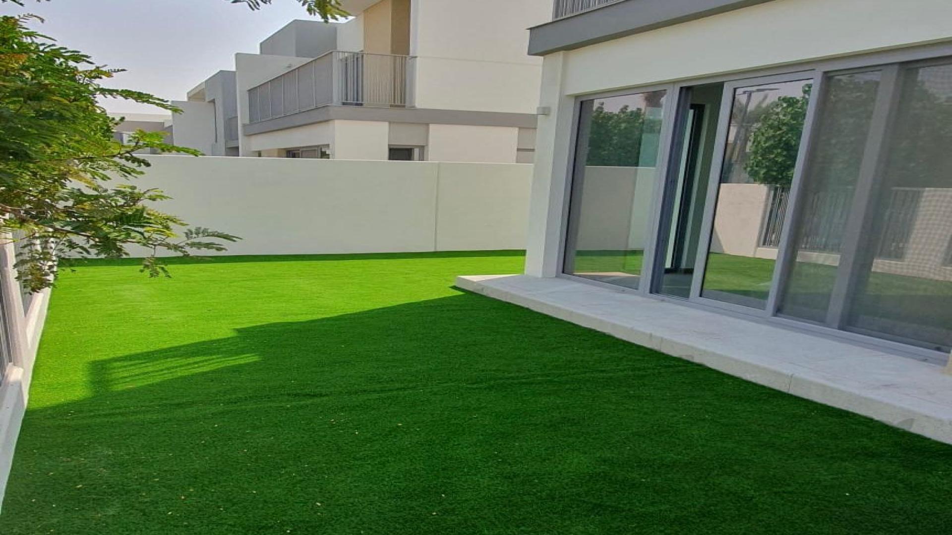 Modern open-plan kitchen and living area in Tilal Al Ghaf townhouse for rent