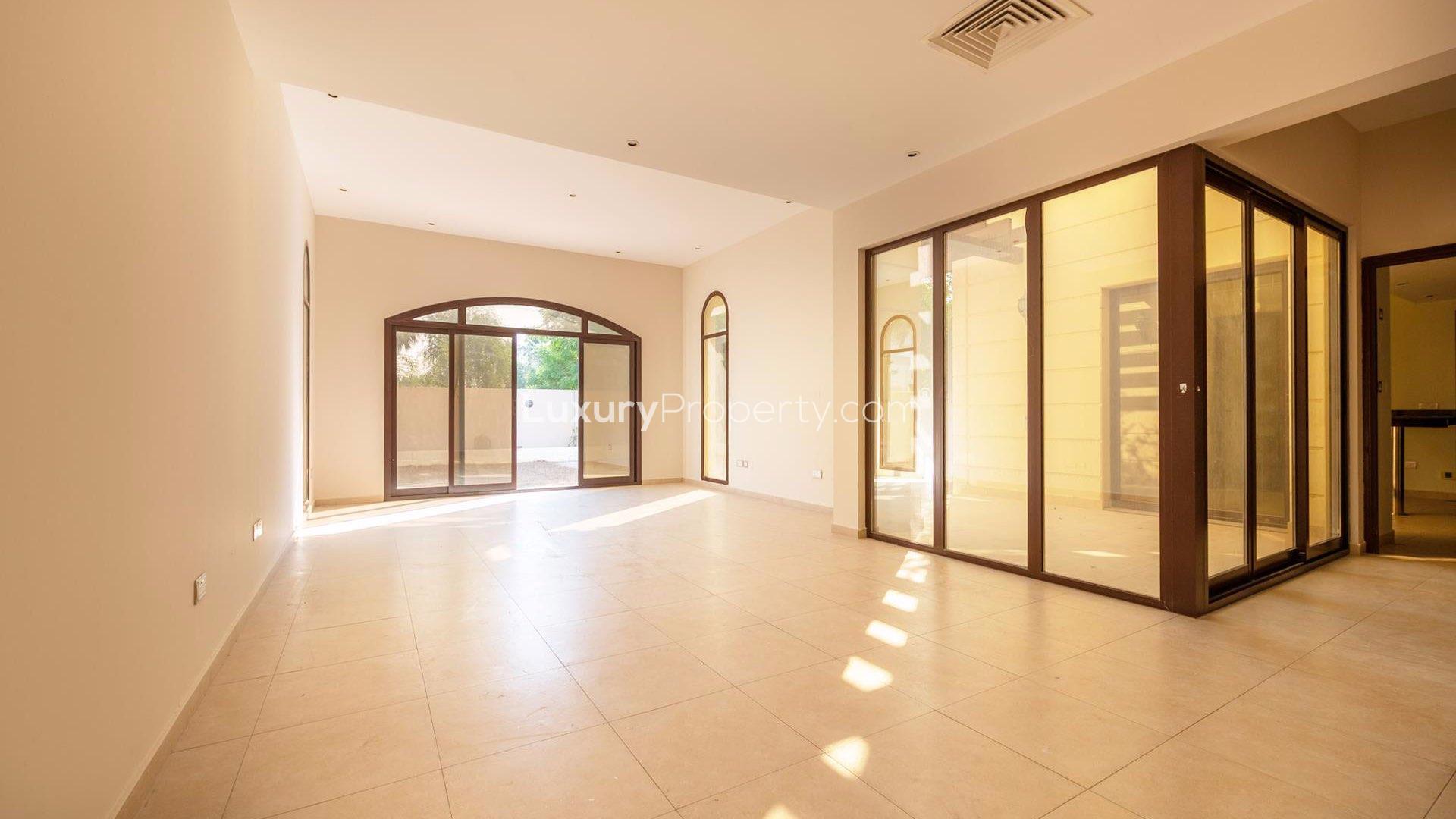 "Spacious living area in vacant 4-bedroom townhouse, Al Salam, Mudon, with large windows.",Bright, spacious living room in Mudon townhouse, featuring large windows and tiled floors