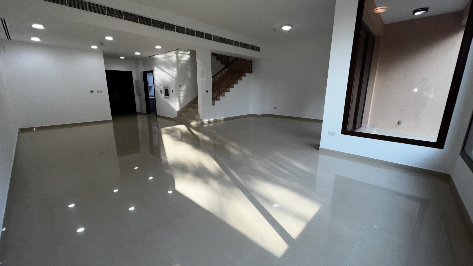 Spacious living area in 4-bedroom townhouse, Jumeirah Islands, with large windows and staircase