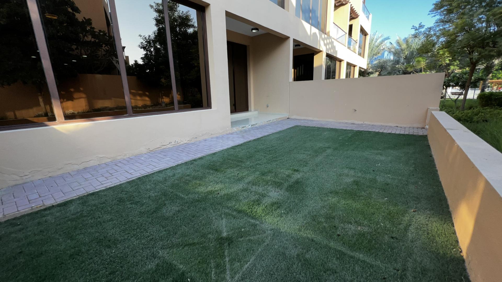 Empty living room in Jumeirah Islands townhouse with modern staircase and large windows