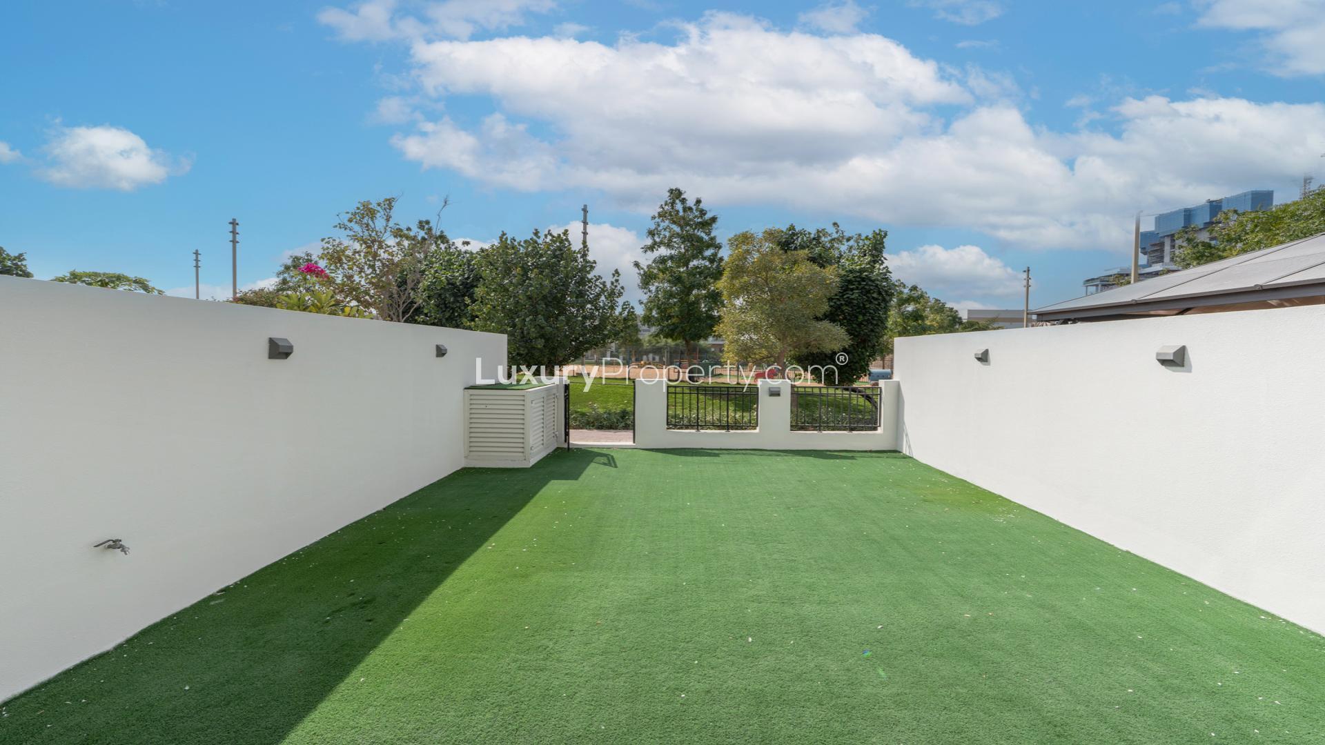Modern townhouse exterior with spacious backyard in Damac Hills, Trinity community for rent