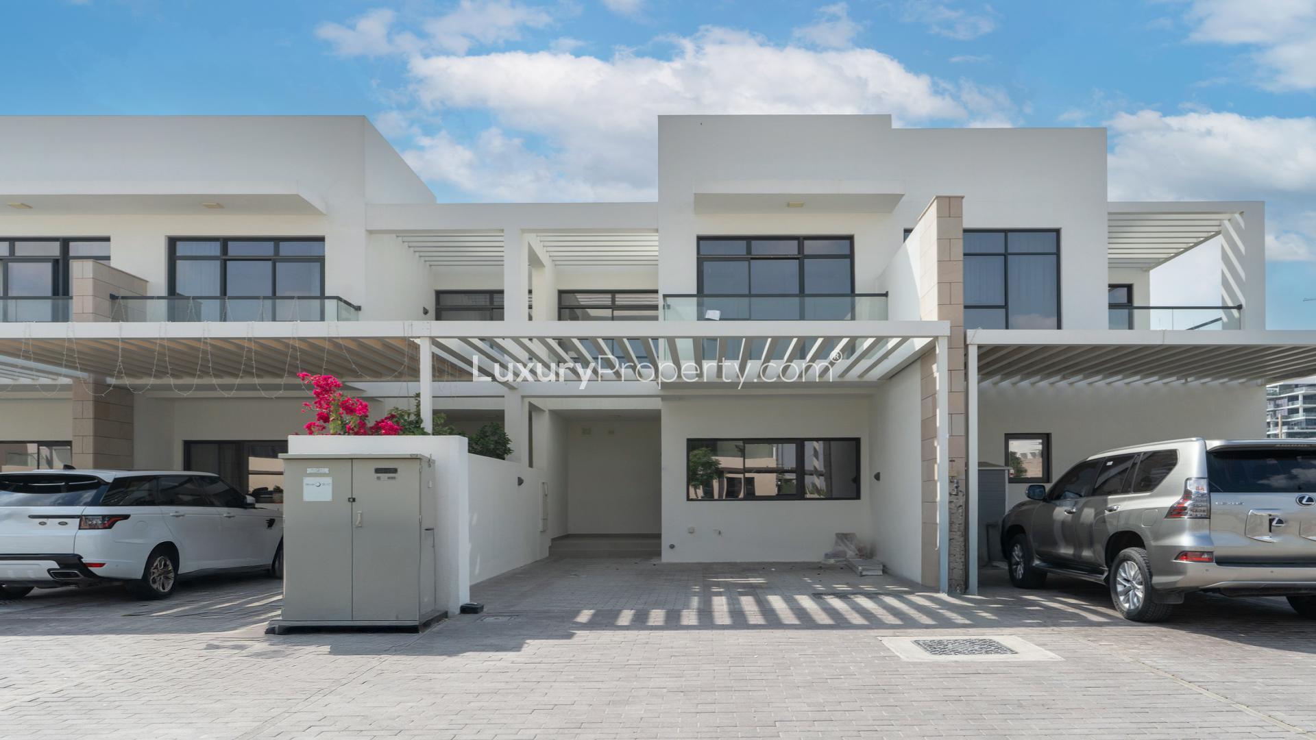 Modern townhouse exterior with spacious backyard in Damac Hills, Trinity community for rent