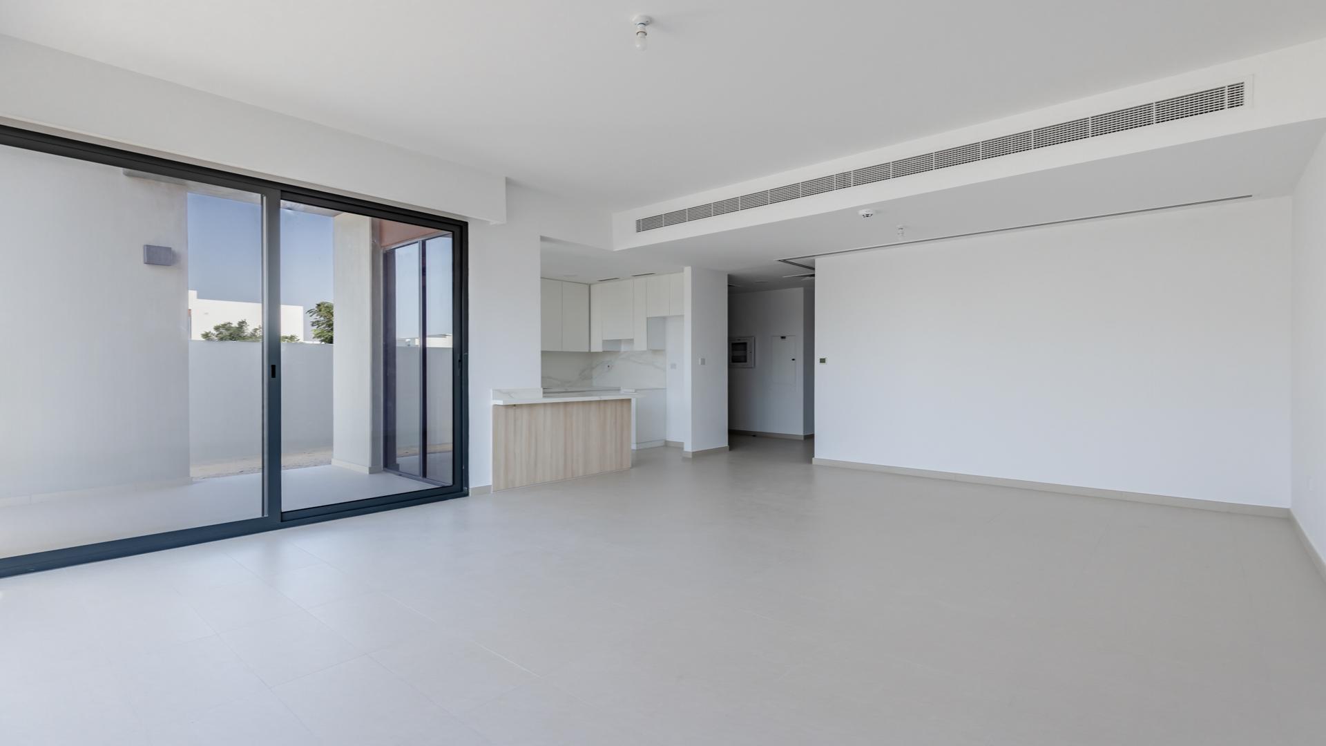 "Cherrywoods townhouse community view, landscaped streets, modern architecture in Dubai Land for rent.",Spacious living area in Cherrywoods townhouse, Dubai Land, with modern design and sliding doors