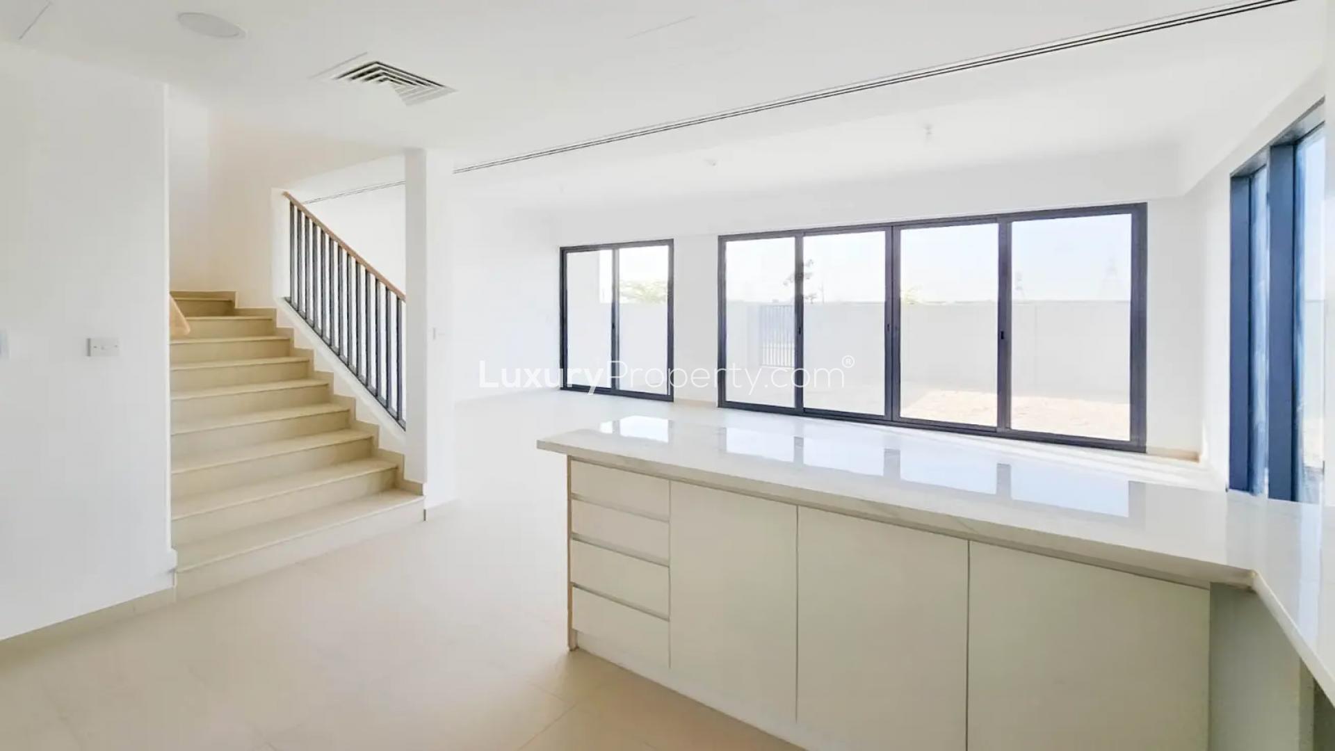 Modern kitchen in Cherrywoods townhouse, Dubai Land, with large windows and sleek design