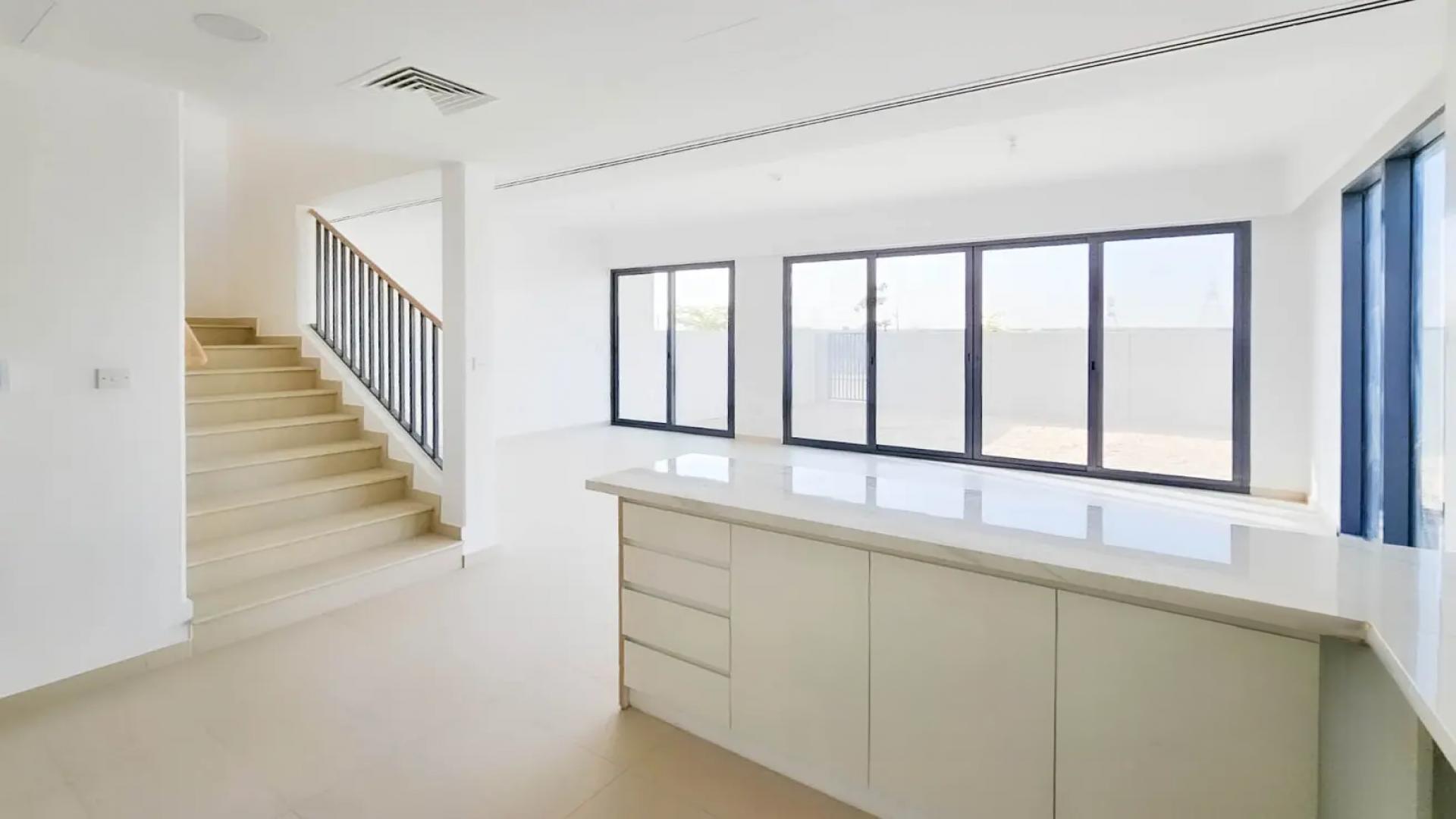 Modern kitchen in Cherrywoods townhouse, Dubai Land, with large windows and sleek design