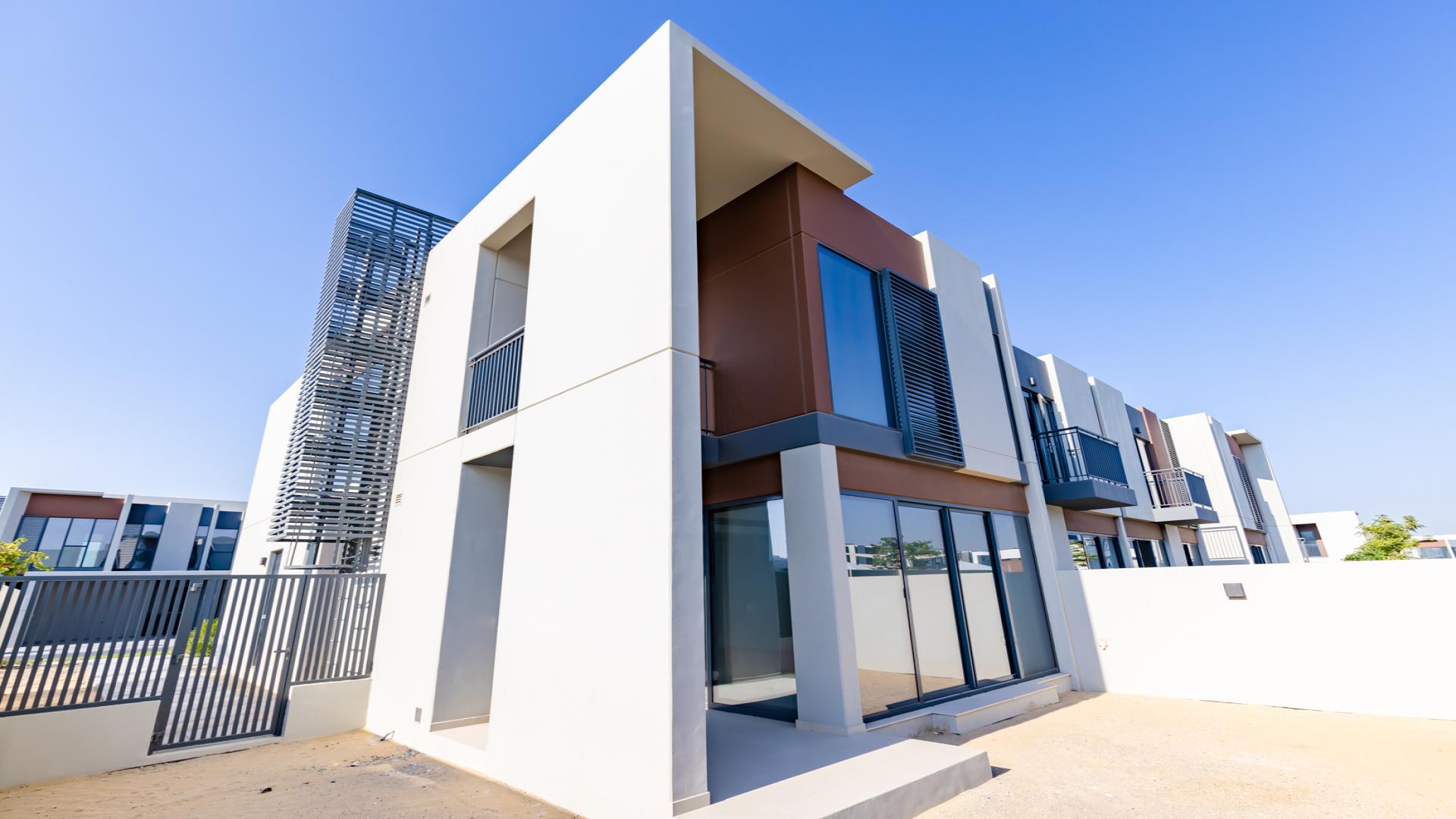 Modern kitchen and living area in Cherrywoods townhouse, Dubai Land, with large windows