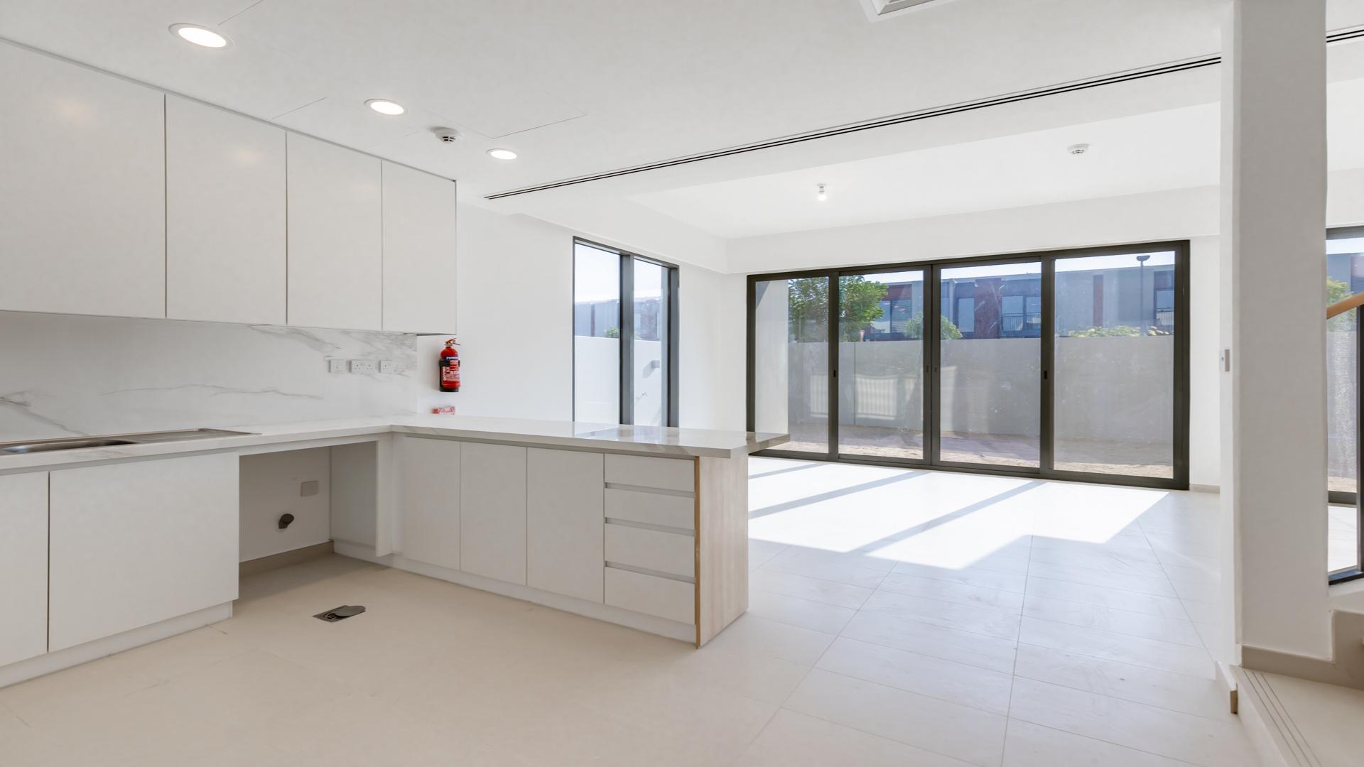 Open-plan living area in Cherrywoods townhouse, featuring modern kitchen and staircase