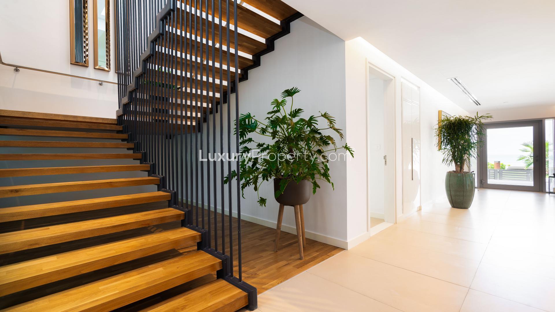 Modern kitchen in luxurious Bluewaters townhouse with sleek white cabinetry and island