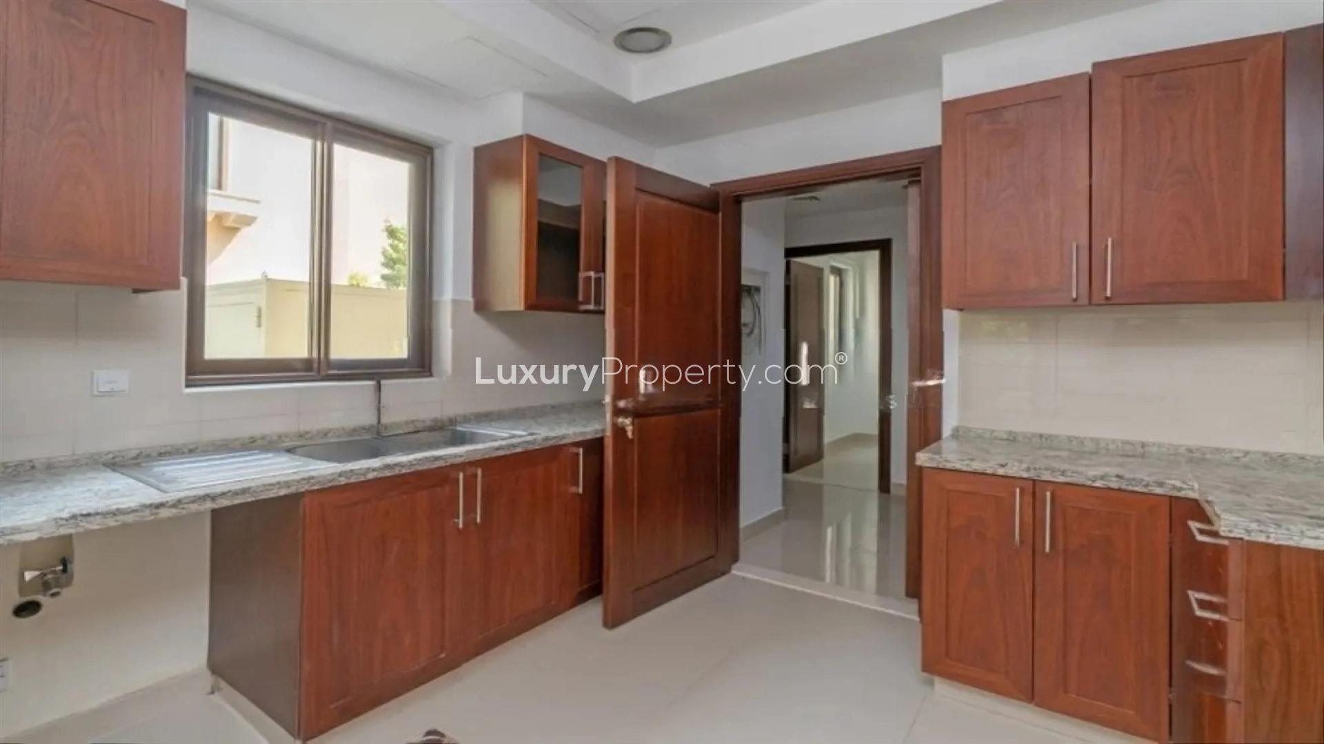 "Spacious living room in 4-bed villa, Samara, Arabian Ranches 2, tiled floor, large windows.","Modern kitchen in 4-bed villa, Arabian Ranches 2, Samara, with wood cabinets and granite countertops.",Empty bedroom with large windows in Samara 4-bed villa, Arabian Ranches 2