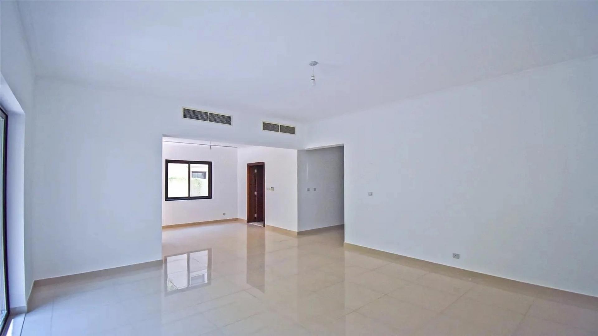 Empty living room with large window overlooking landscaped garden in Samara villa