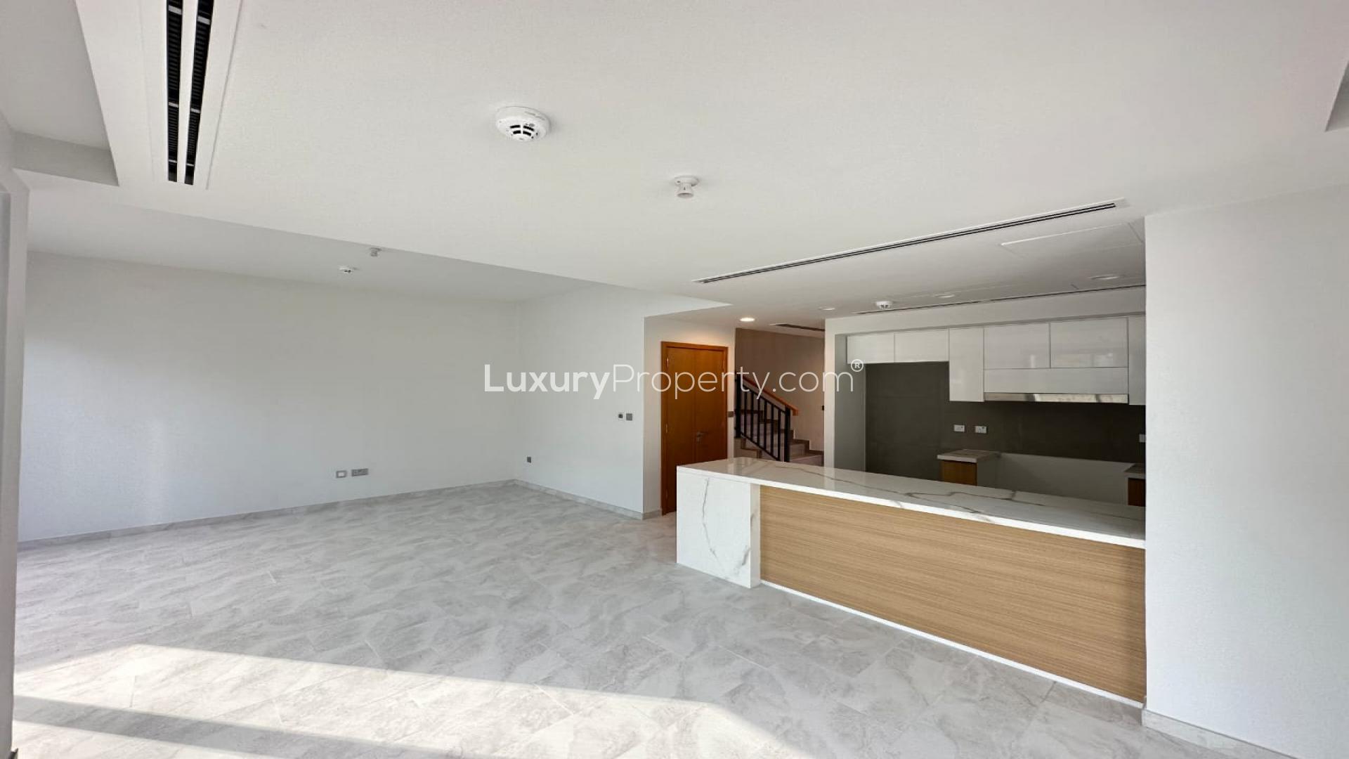 Modern kitchen and living area in La Rosa townhouse, Villanova, Dubai Land