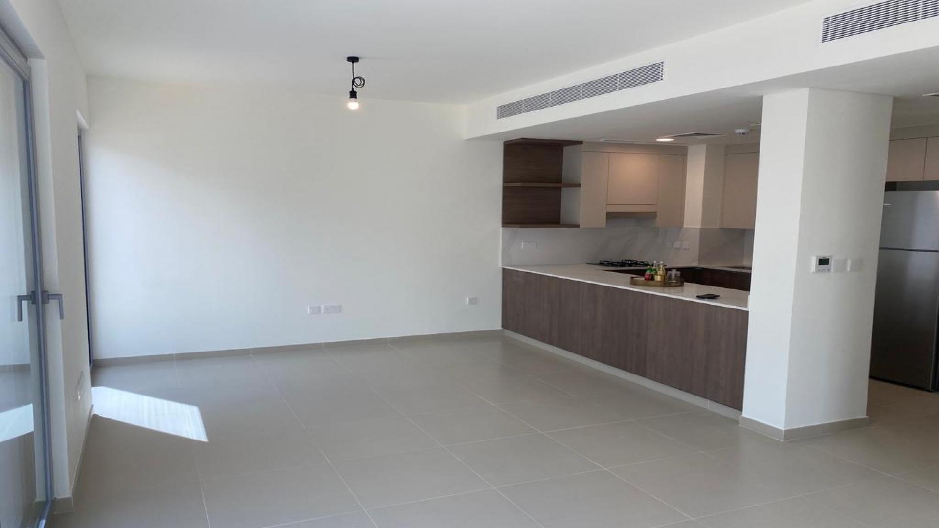 Modern kitchen in 4-bedroom Elan Townhouse, Tilal Al Ghaf, Dubai, with sleek wood cabinets
