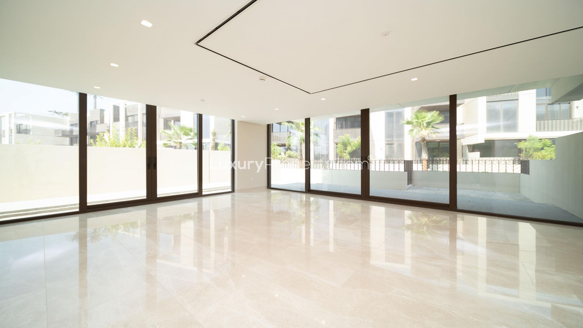 Luxurious empty living room in Jumeirah Bay townhouse with large windows and marble flooring