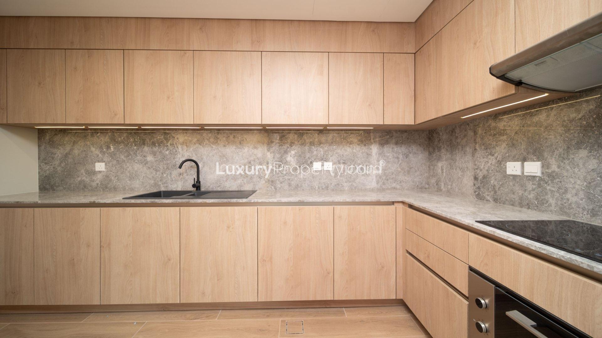Modern kitchen in Jumeirah Bay Island townhouse with sleek wooden cabinetry and marble countertops