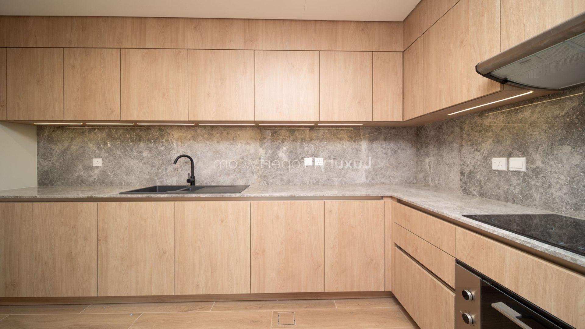 Modern kitchen in Jumeirah Bay Island townhouse with sleek wooden cabinetry and marble countertops