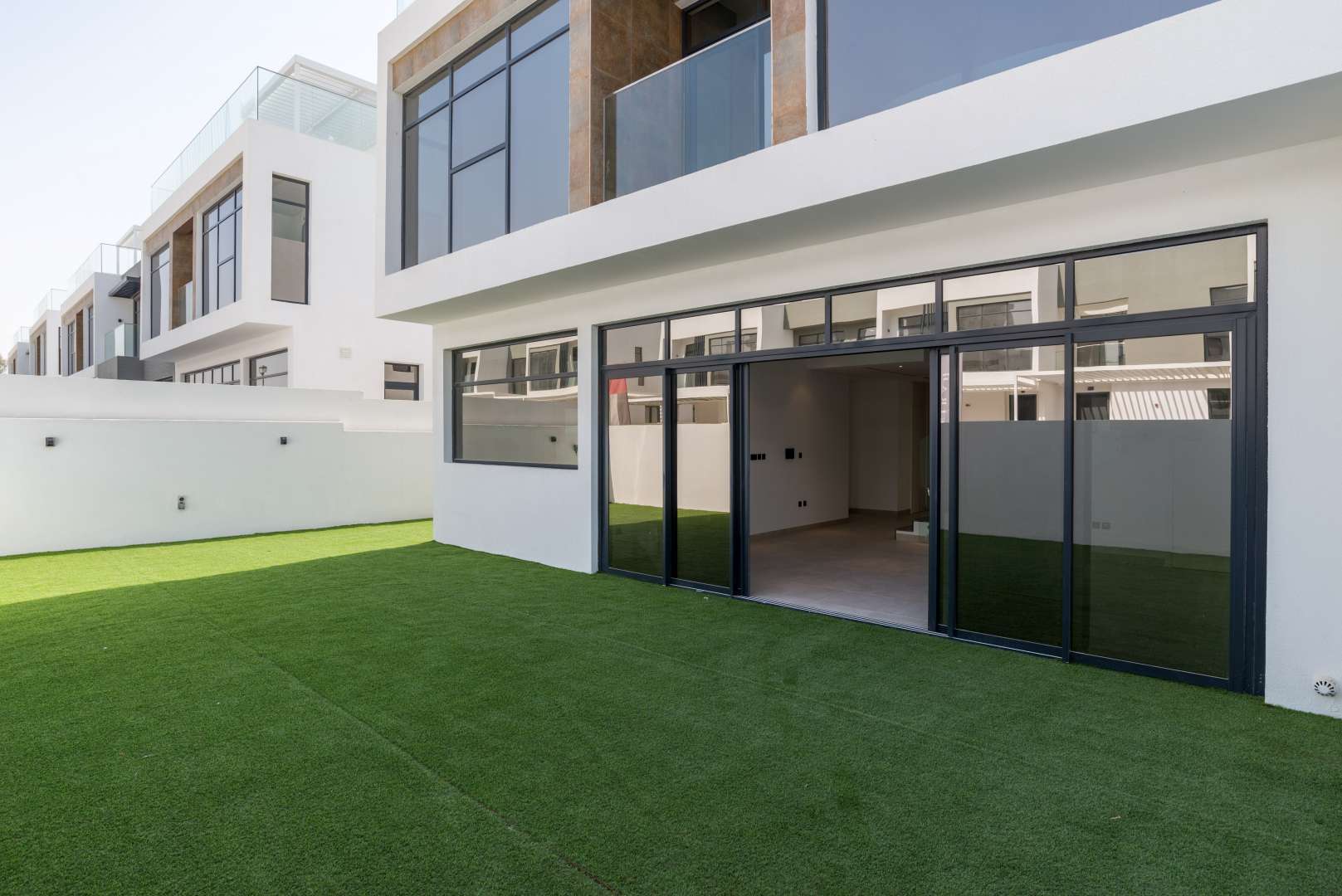 Modern townhouse exterior with spacious lawn in Jumeirah Luxury, Jumeirah Golf Estates