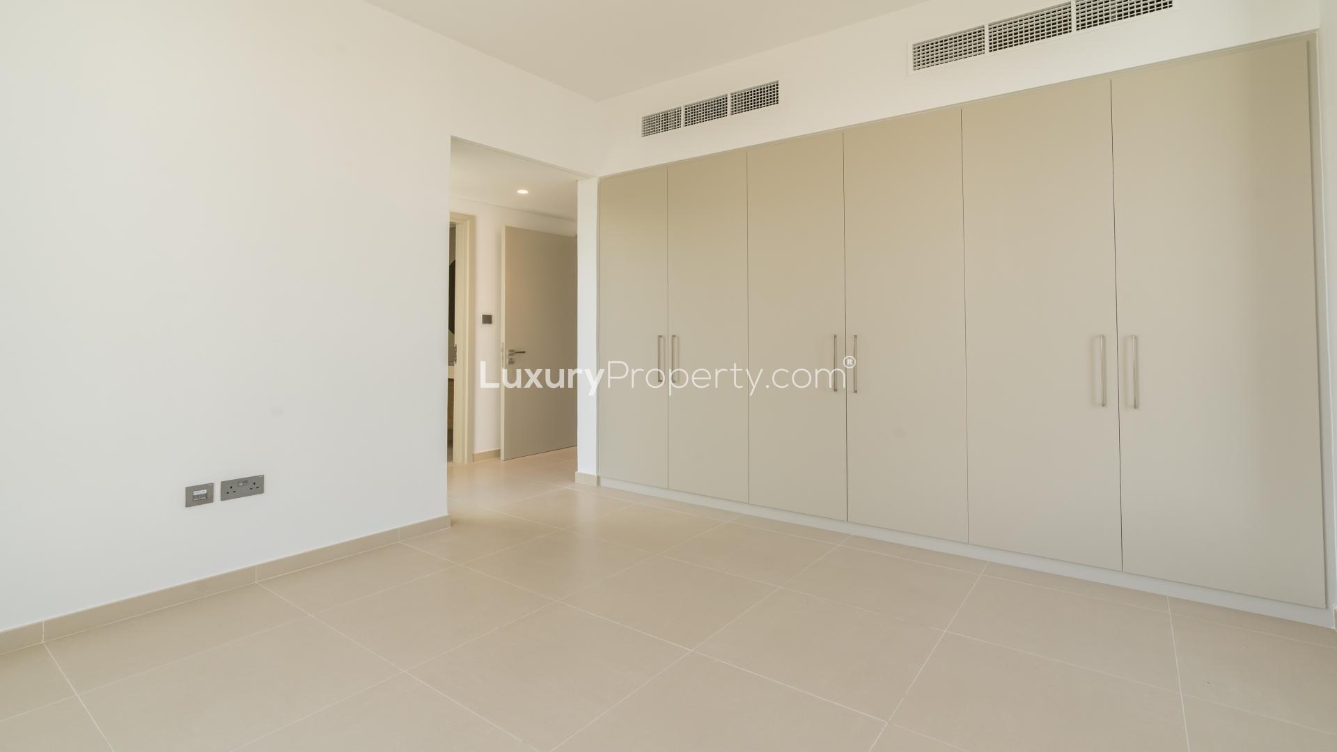 Empty bedroom with built-in wardrobe and open door to staircase in townhouse, Joy, Arabian Ranches III