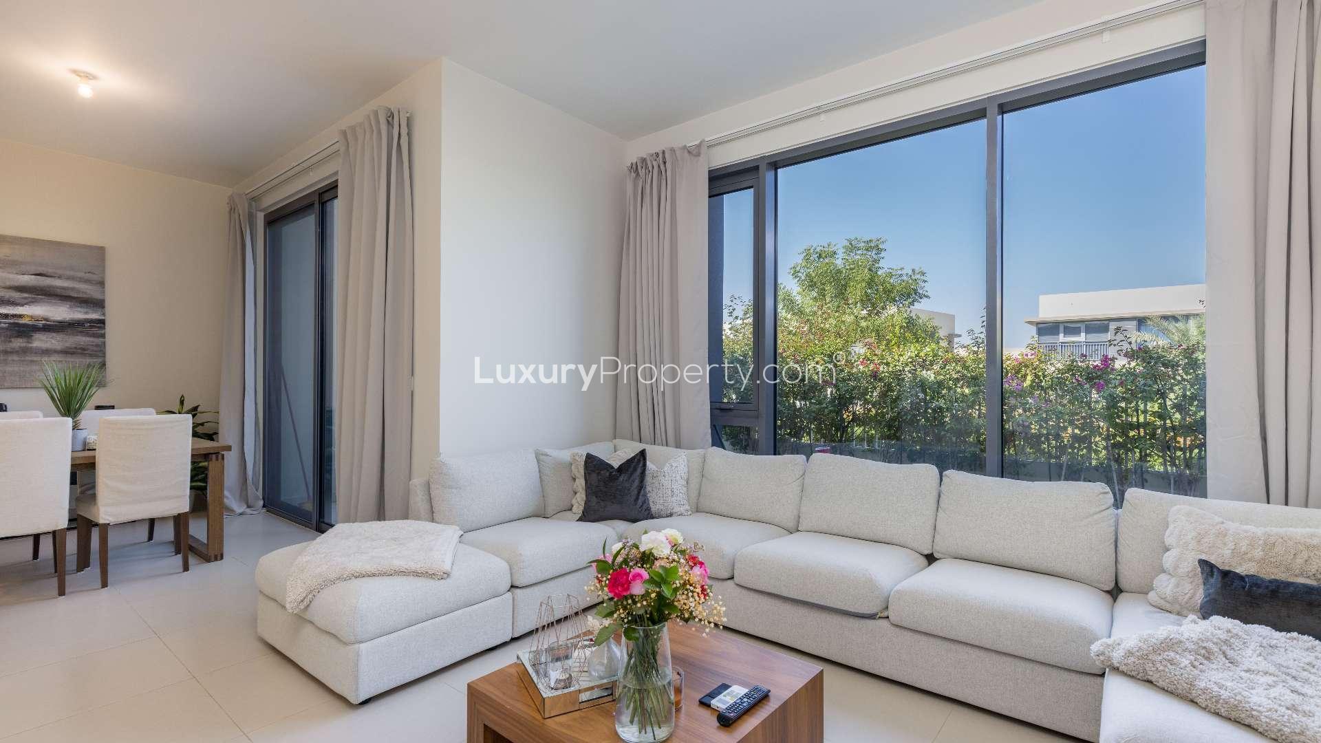 Living room in 4-bedroom townhouse, Maple, Dubai Hills Estate, with modern decor and garden view