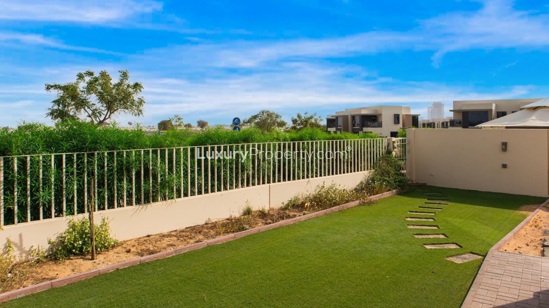 "Bright living room with garden view in Dubai Hills Estate townhouse for rent.",Alt text: "Garden view of single row villa in Maple at Dubai Hills Estate, near camel track.",Modern kitchen in 4-bedroom villa, Dubai Hills Estate, Maple, spacious countertops and cabinets