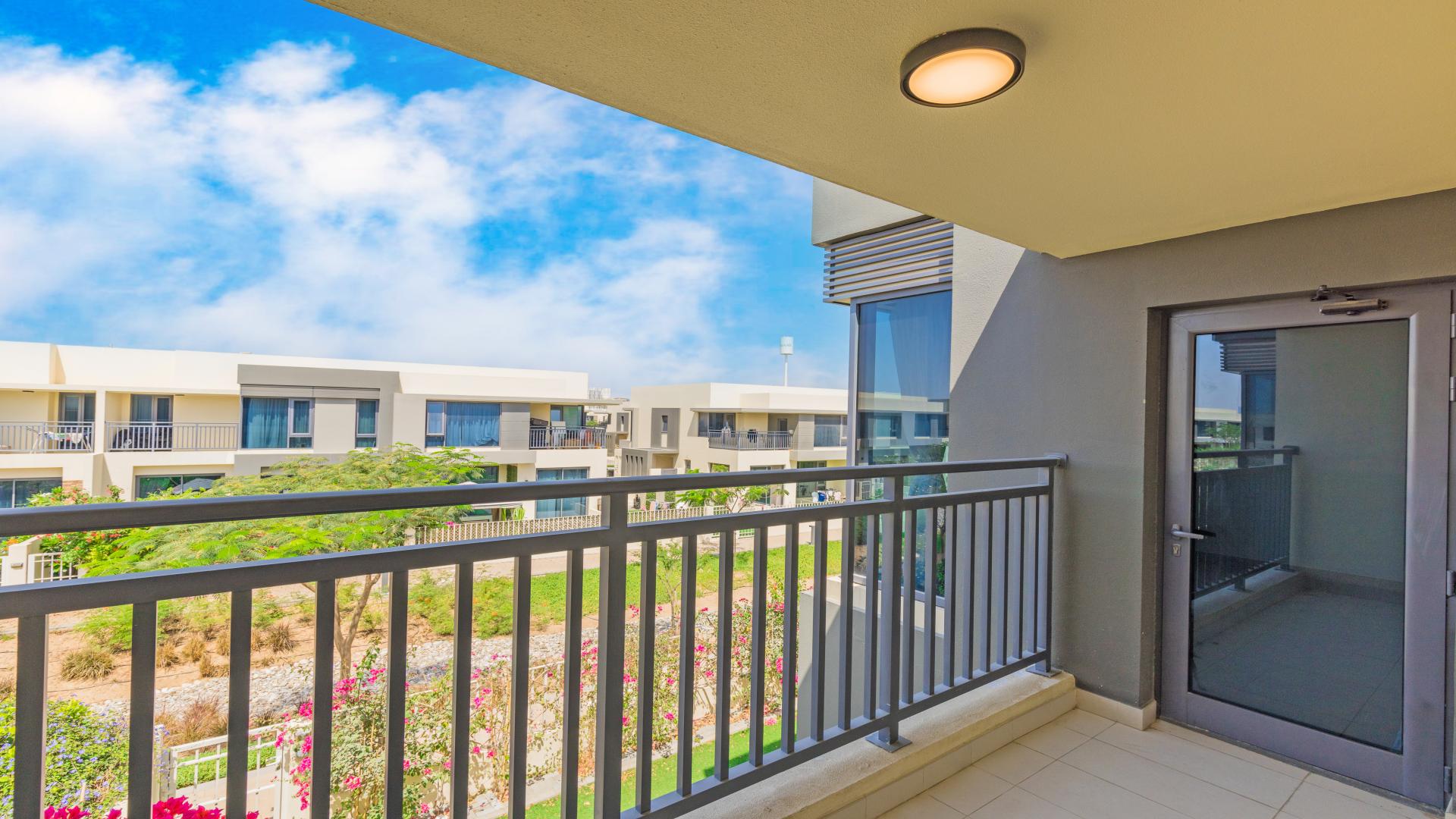 Empty living room with large windows overlooking landscaped yard in Dubai Hills Estate townhouse