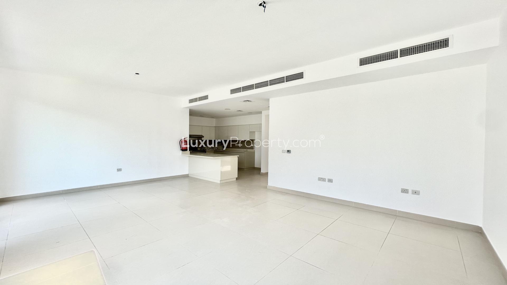 Spacious living room in Maple villa, Dubai Hills Estate, with large windows and garden view