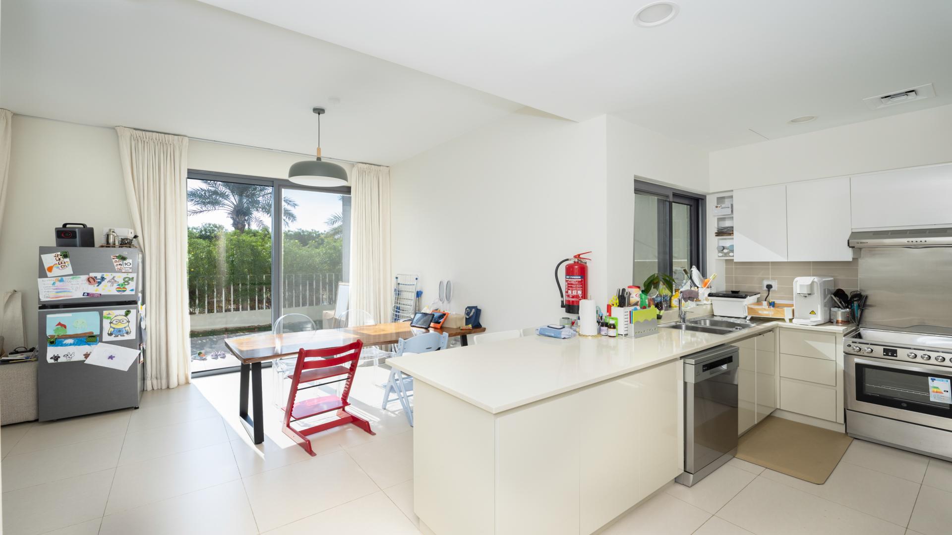 Bright living area in Maple Dubai Hills Estate villa with garden view through large windows