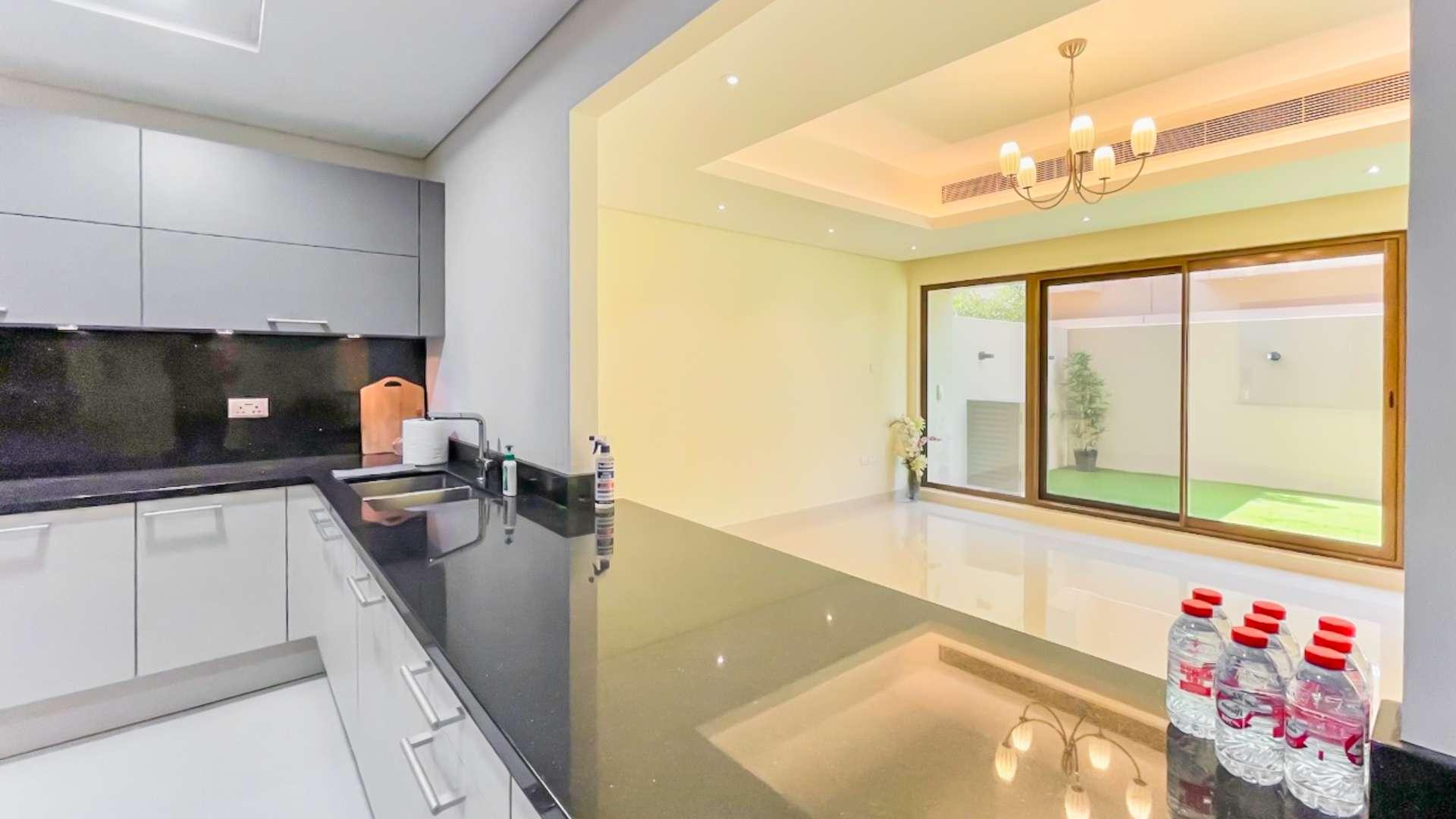 Spacious living room in Meydan townhouse with modern chandelier and large windows