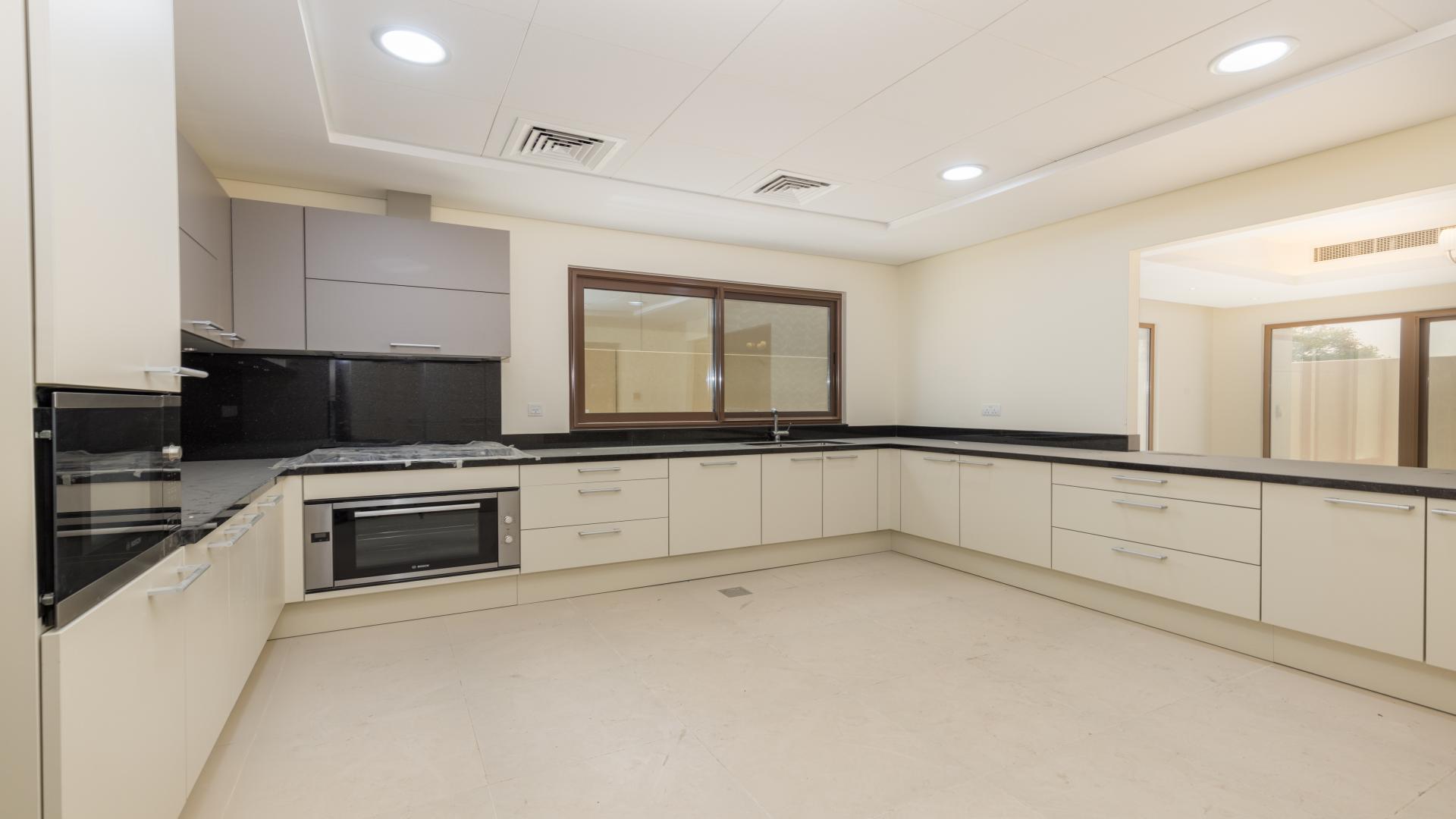 "Spacious living room in Meydan townhouse with modern chandeliers and large windows for rent.",Brand new modern kitchen in Meydan townhouse, featuring sleek cabinetry and ample counter space