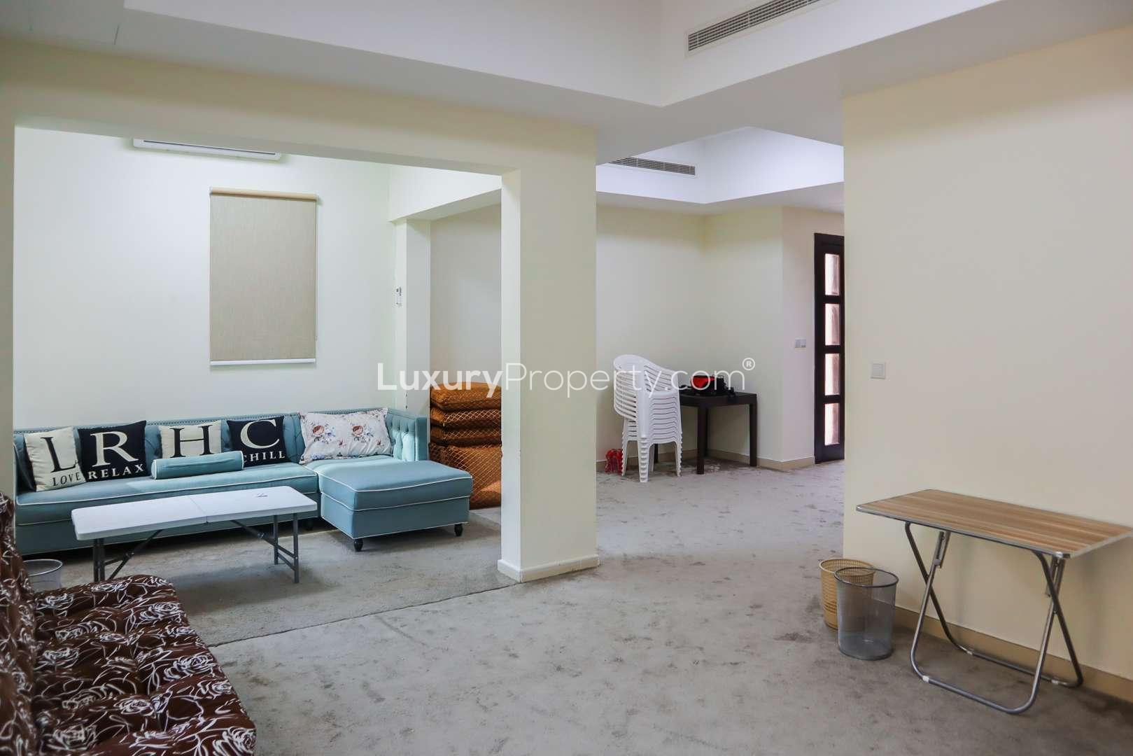 End-unit townhouse in Mira, Reem Community, Dubai, with tree-lined street and garages