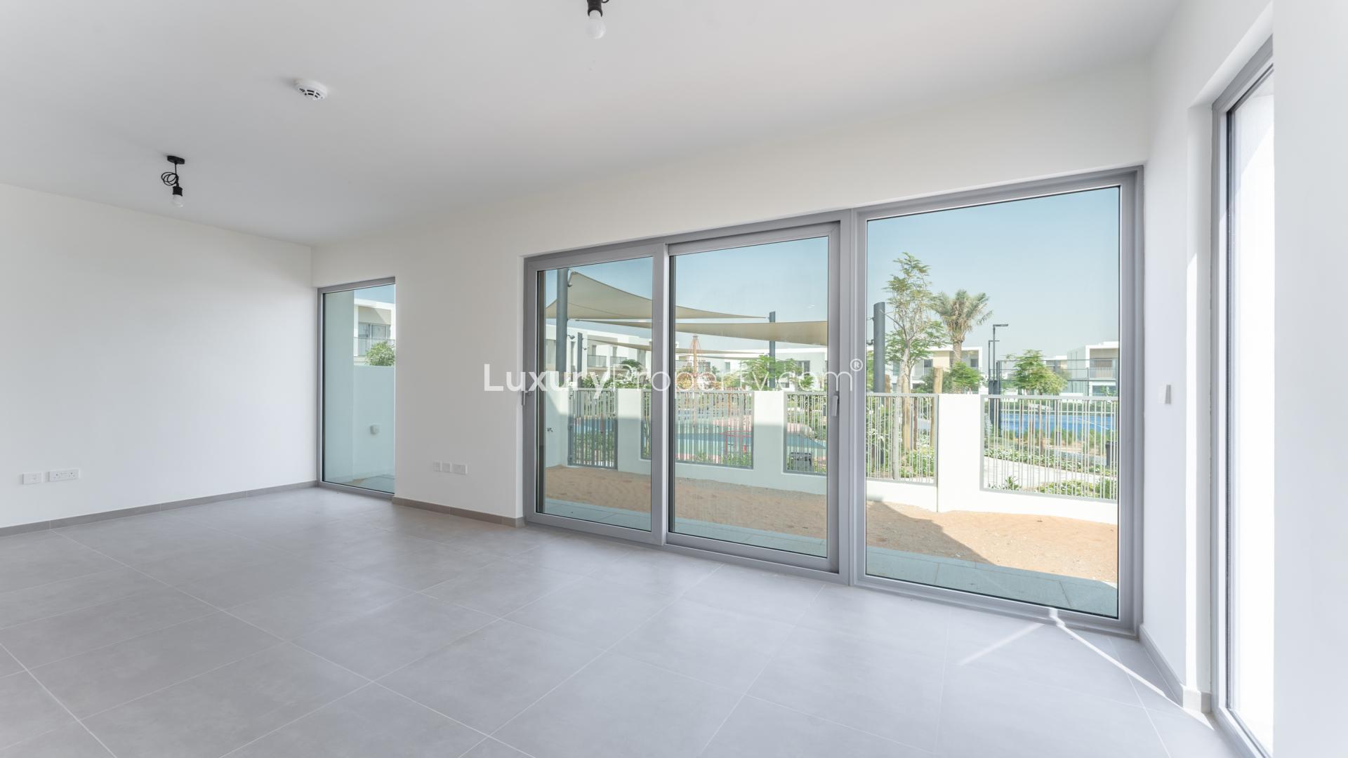 "Modern townhouse balcony view in Elan, Tilal Al Ghaf community, LP37445, for rent.",Spacious living room with large windows in Tilal Al Ghaf townhouse, Elan community