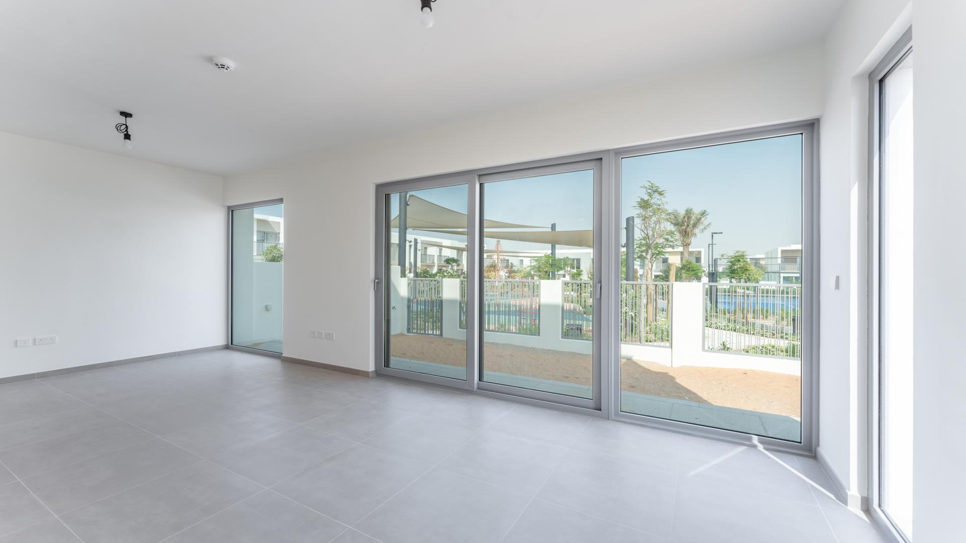 "Modern townhouse balcony view in Elan, Tilal Al Ghaf community, LP37445, for rent.",Spacious living room with large windows in Tilal Al Ghaf townhouse, Elan community