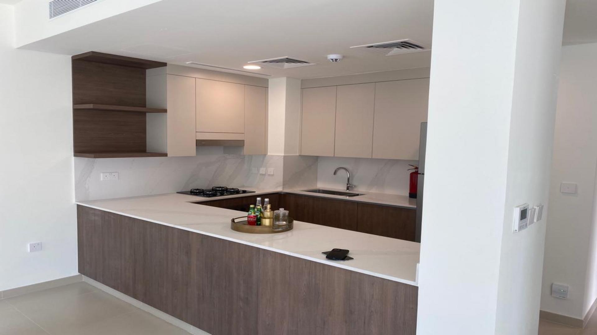 Modern kitchen in 4-bedroom townhouse, Elan, Tilal Al Ghaf, featuring sleek cabinetry and appliances