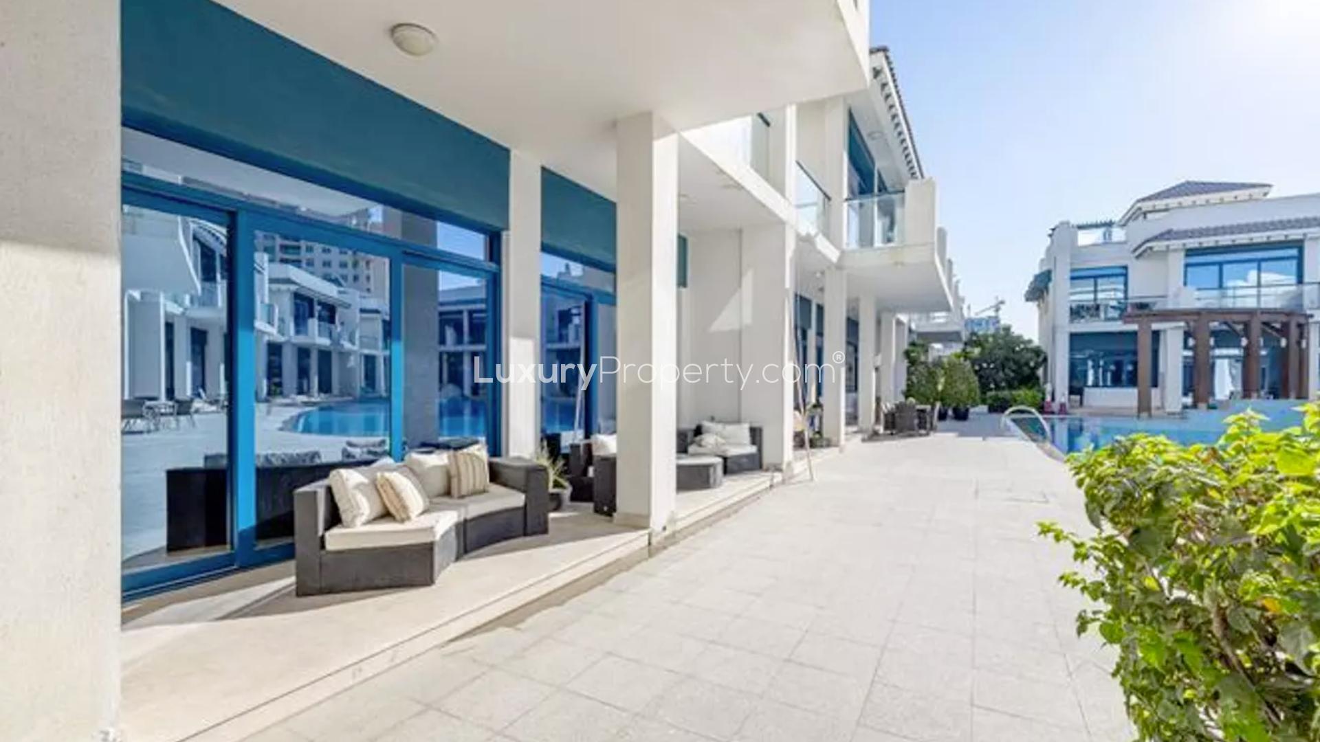 "Balcony view of Palma Residences townhouse overlooking pool in Palm Jumeirah, Dubai.",Beachfront townhouse patio with pool view at Palma Residences, Palm Jumeirah