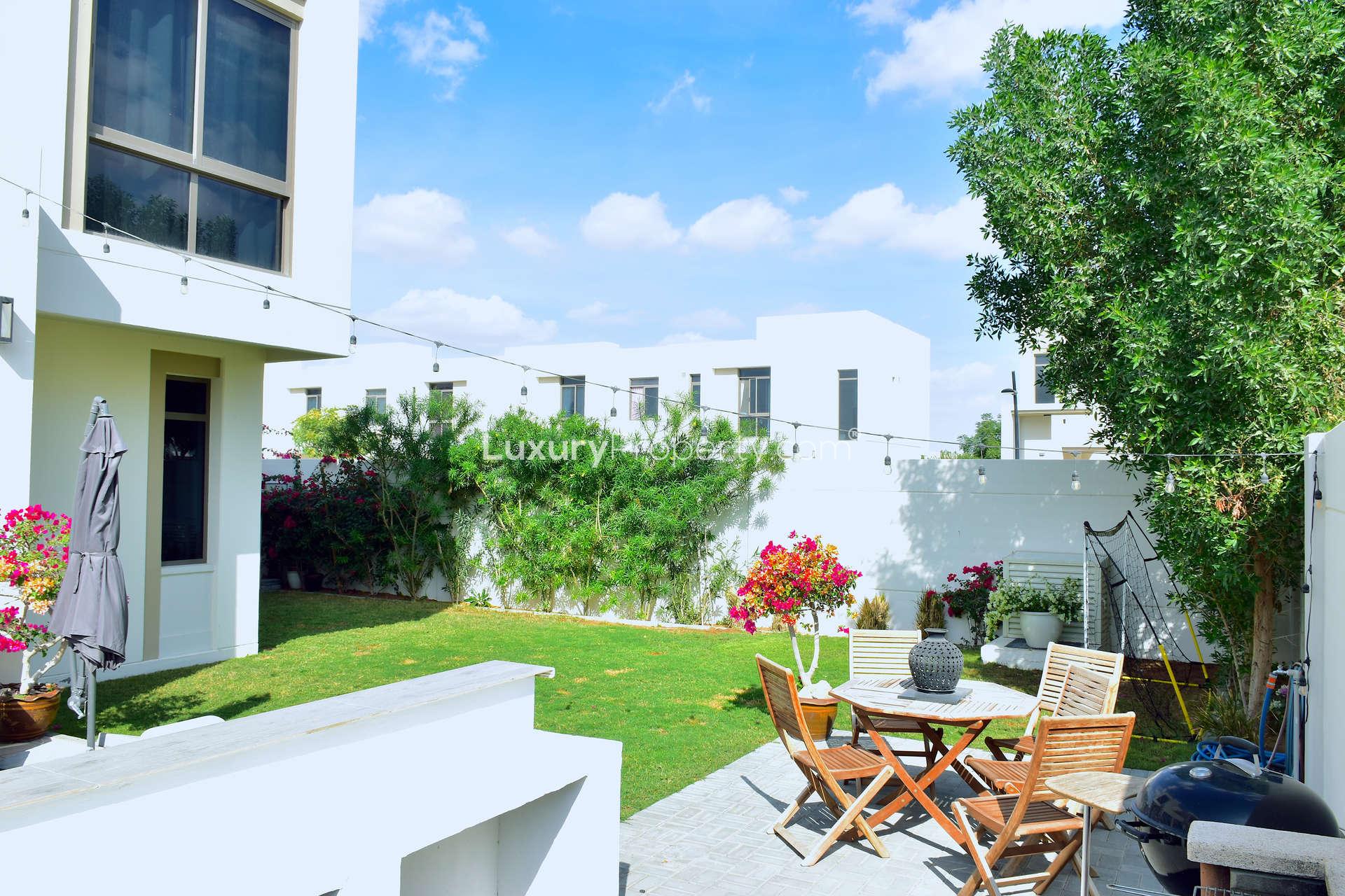 Backyard view of Zahra Townhouse for rent in Town Square, lush greenery and lawn