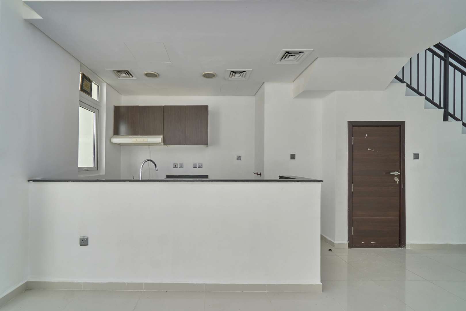 "Spacious living area with large windows in 4-bedroom villa, Damac Hills 2, Sanctuary.",Modern kitchen in 4-bedroom villa, Sanctuary, Damac Hills 2 townhouse for rent