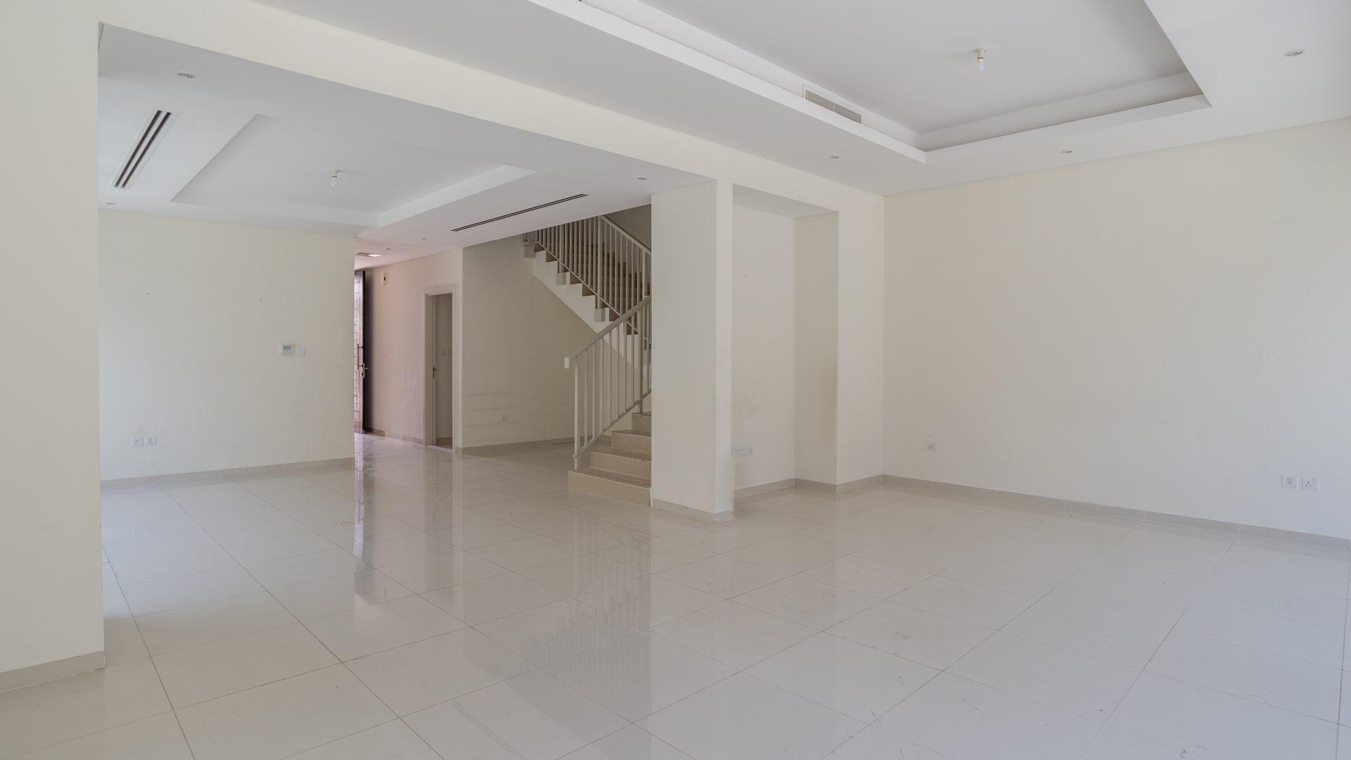 Spacious living area in 4-bedroom townhouse, Damac Hills, The Field, with large windows and stairs
