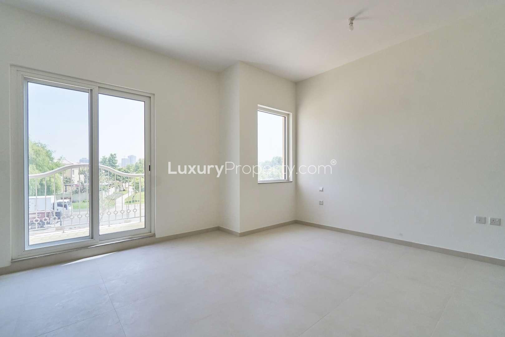 Empty room with large windows in 4-bed townhouse, Victory Heights, Dubai Sports City