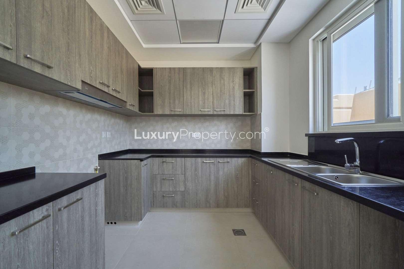 Brand new townhouse exterior with lush greenery in Victory Heights, Dubai Sports City
