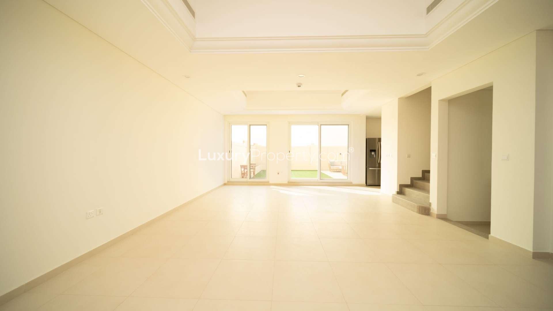 Spacious living room in Victory Heights townhouse, Dubai Sports City, with garden view
