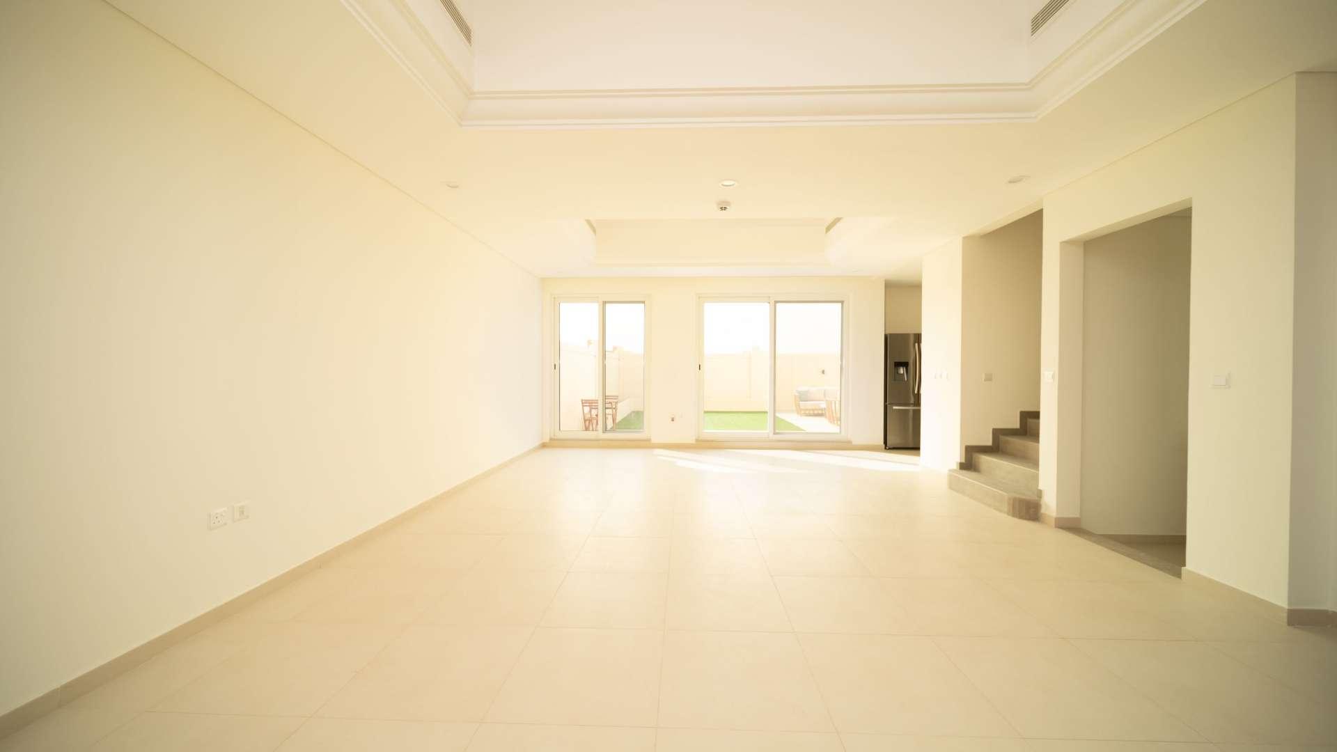 Spacious living room in Victory Heights townhouse, Dubai Sports City, with garden view