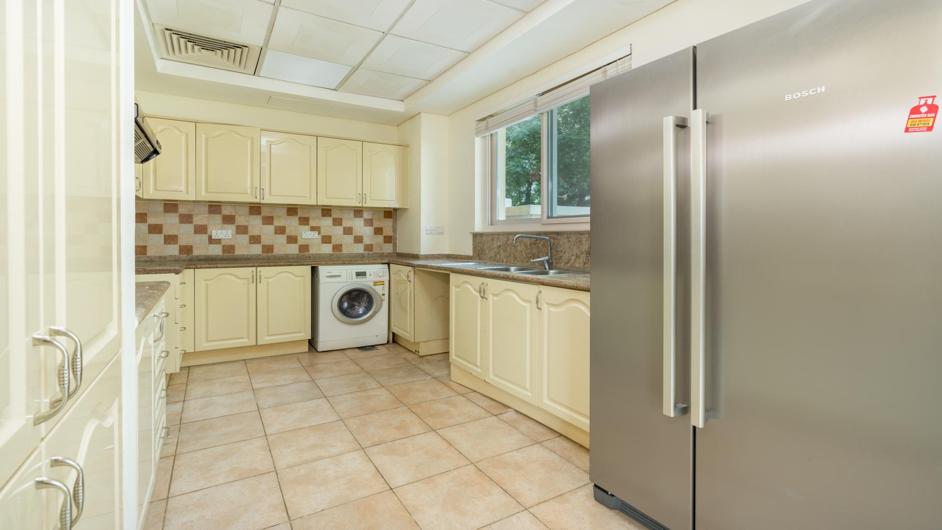 Spacious living room with large windows in Victory Heights townhouse, Dubai Sports City