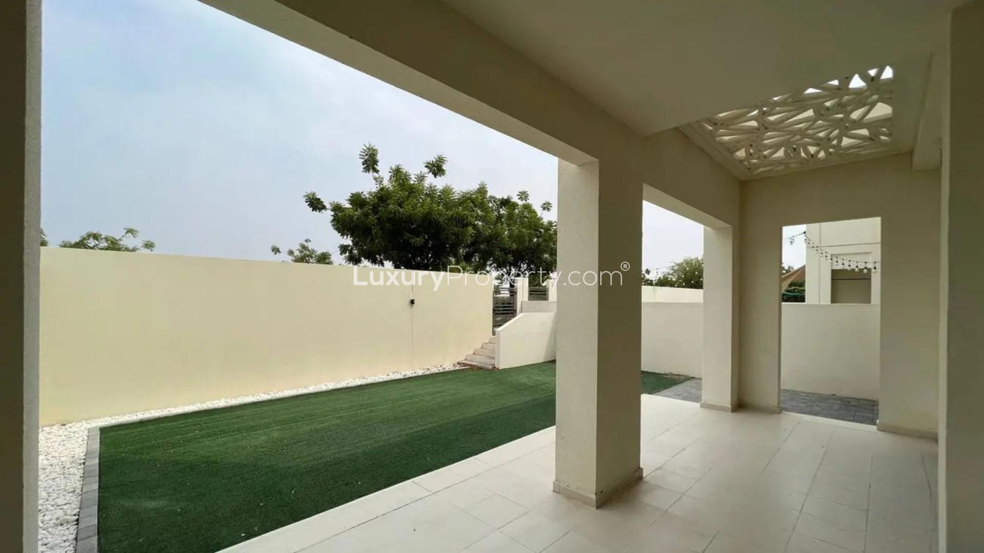 "Modern kitchen in 4-bedroom Mira Oasis townhouse, Reem community, with granite countertops and large window.",Covered patio and landscaped backyard of townhouse in Mira Oasis 2, Reem community