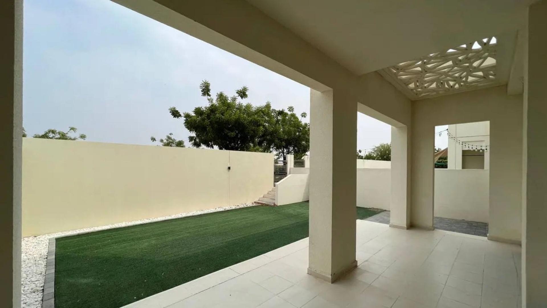 "Modern kitchen in 4-bedroom Mira Oasis townhouse, Reem community, with granite countertops and large window.",Covered patio and landscaped backyard of townhouse in Mira Oasis 2, Reem community