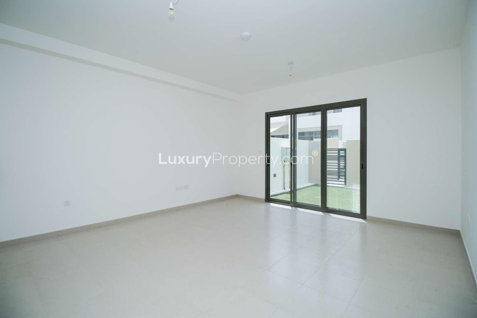 Modern kitchen and living area in Zahra Townhouses, Town Square, Dubai