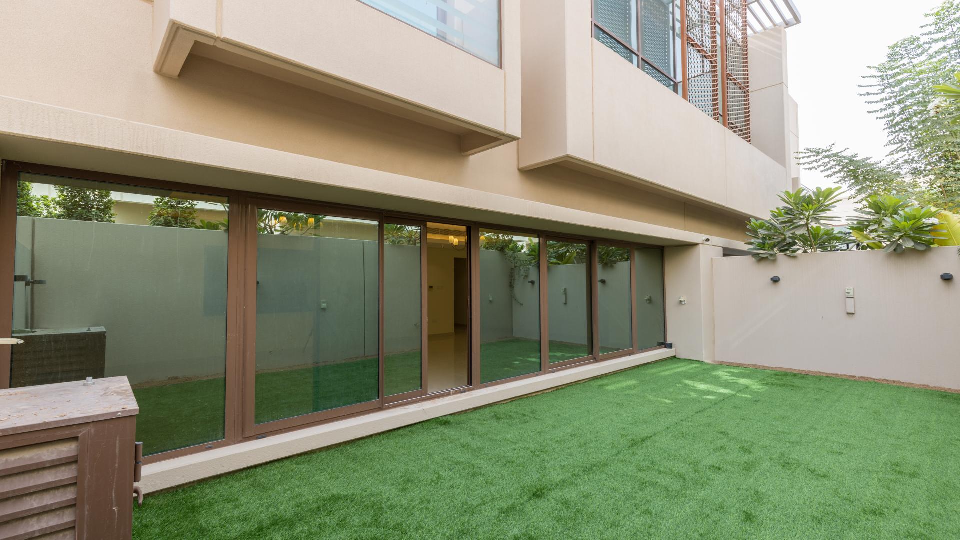 Spacious living room in Meydan townhouse with large windows and elegant lighting fixtures