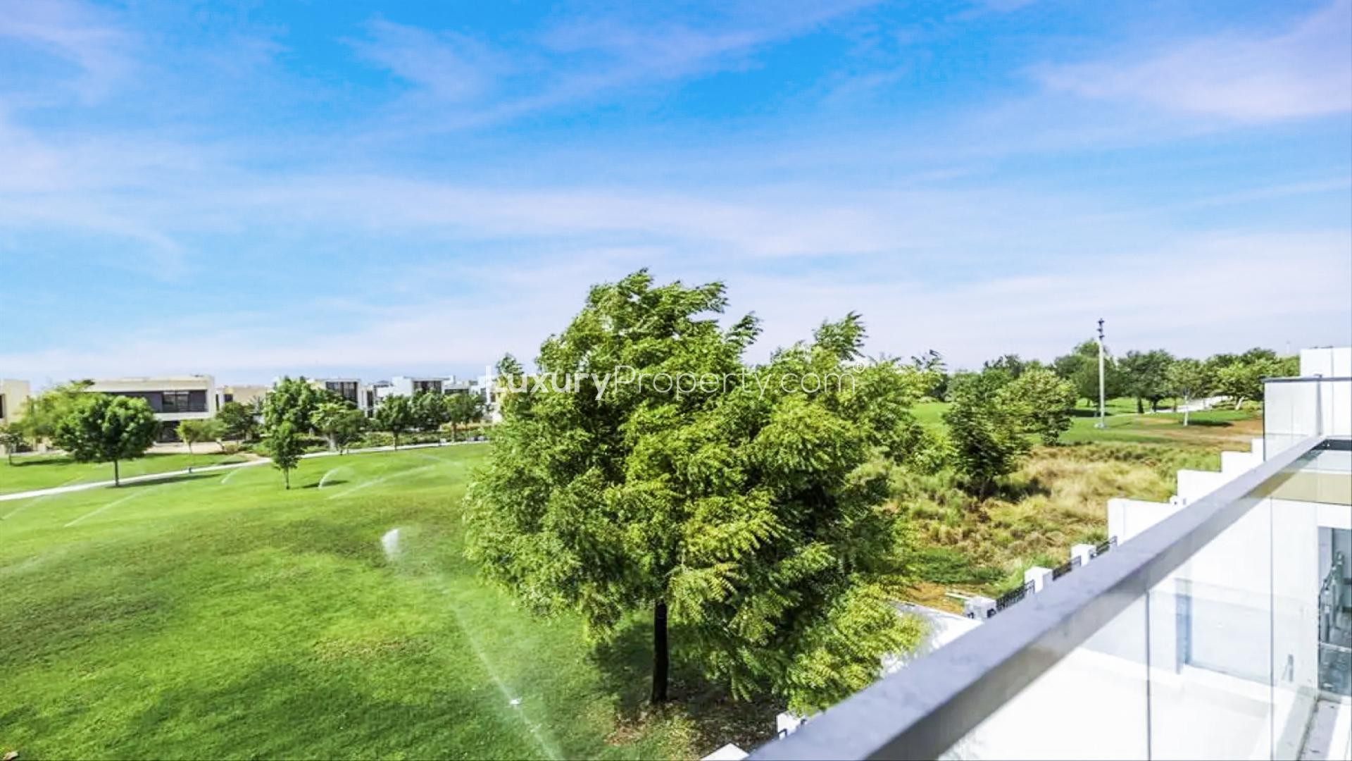 "Spacious living area in modern Damac Hills townhouse, featuring open floor plan and staircase.",Townhouse balcony view of lush park in Damac Hills, Dubai, Park Residences