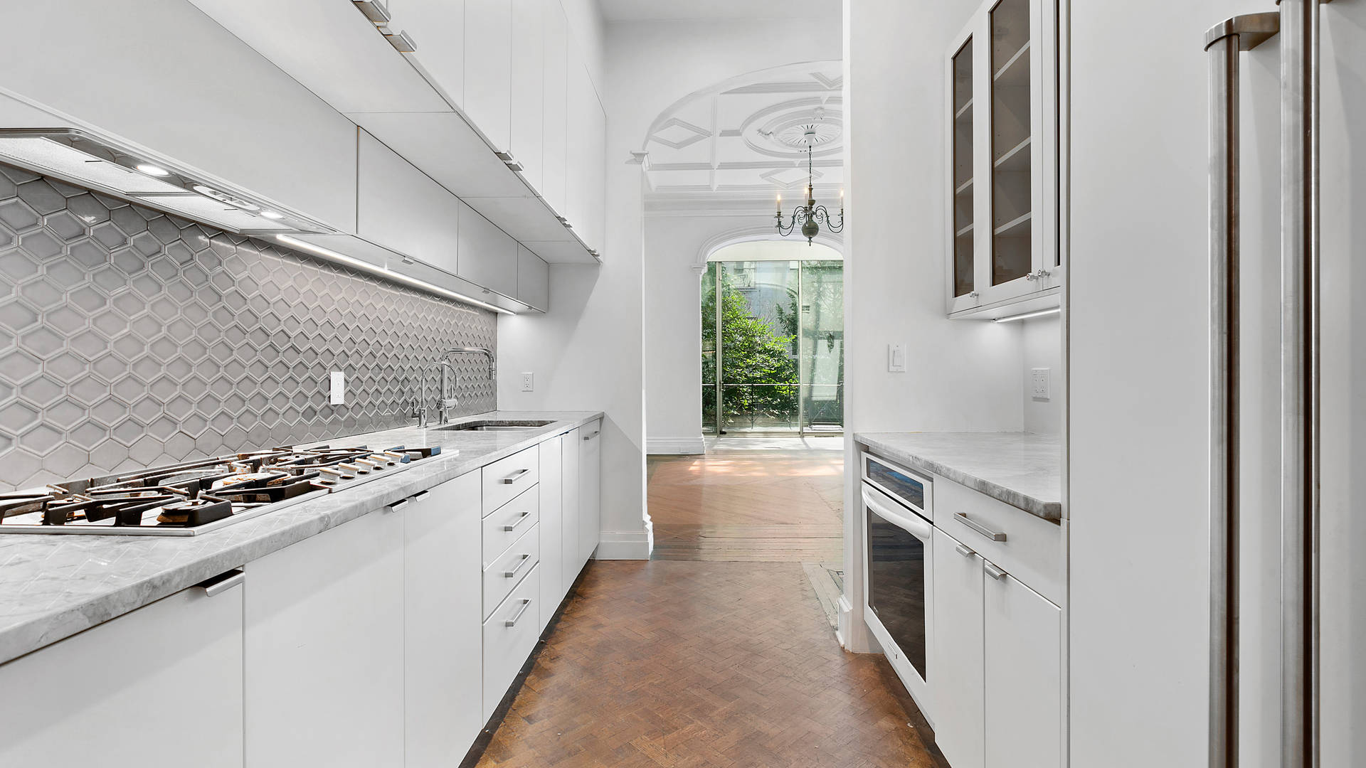 Spacious townhouse entry with large glass doors and lush greenery, Manhattan, NY
