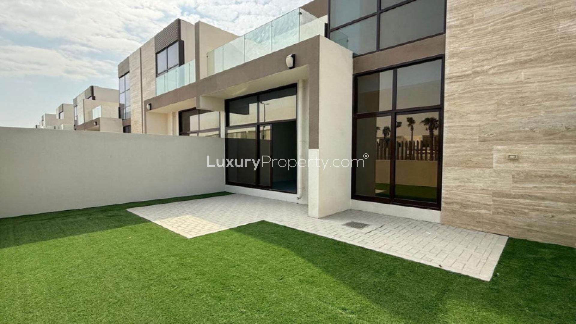 "Spacious Elie Saab townhouse kitchen with large windows, Meydan community, for sale.",Vacant Elie Saab townhouse exterior with lawn, Meydan community, next to pool and park